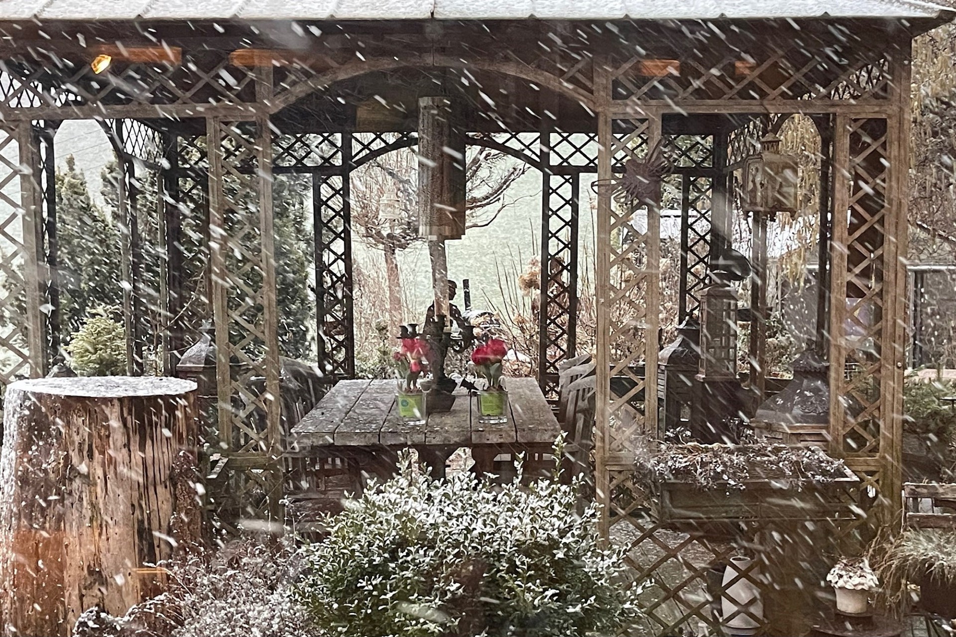 Verschneiter Gartenpavillon mit rustikaler Holzpergola