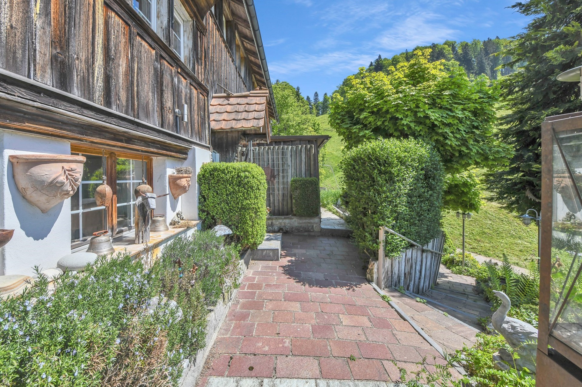Alpiner Außenbereich mit Holzfassade und Gartenweg