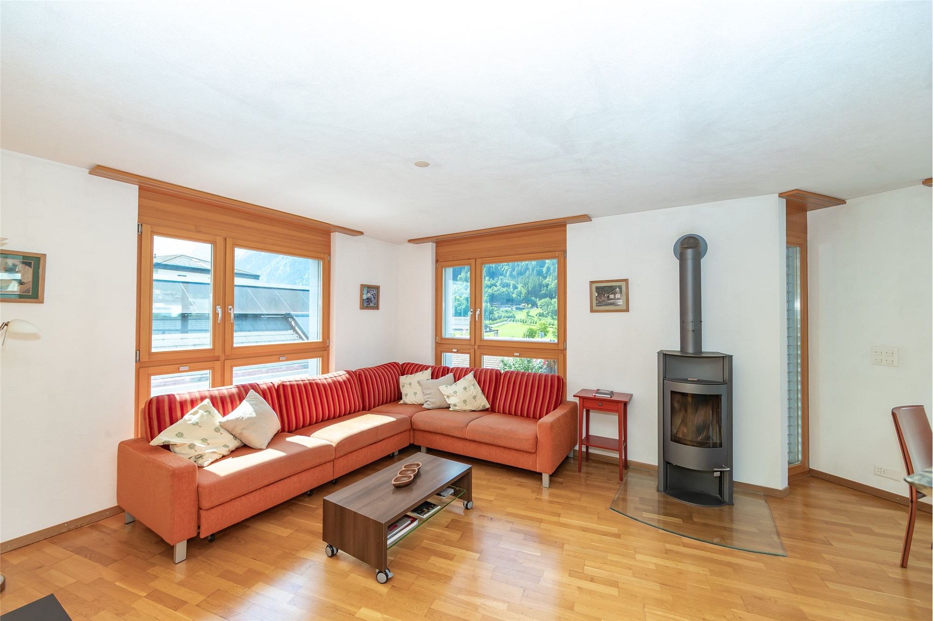 Heller Wohnraum mit Ecksofa und Kaminofen