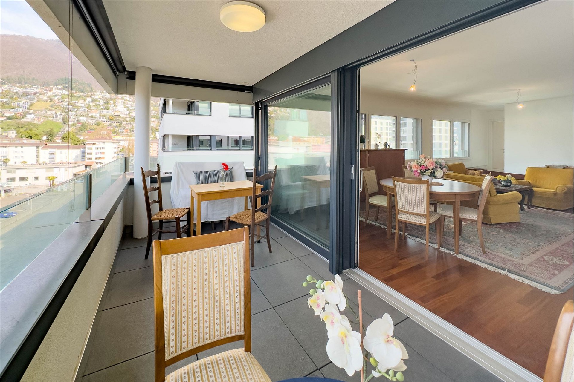 Balkon mit Ausblick in eine Wohn-/Esssituation