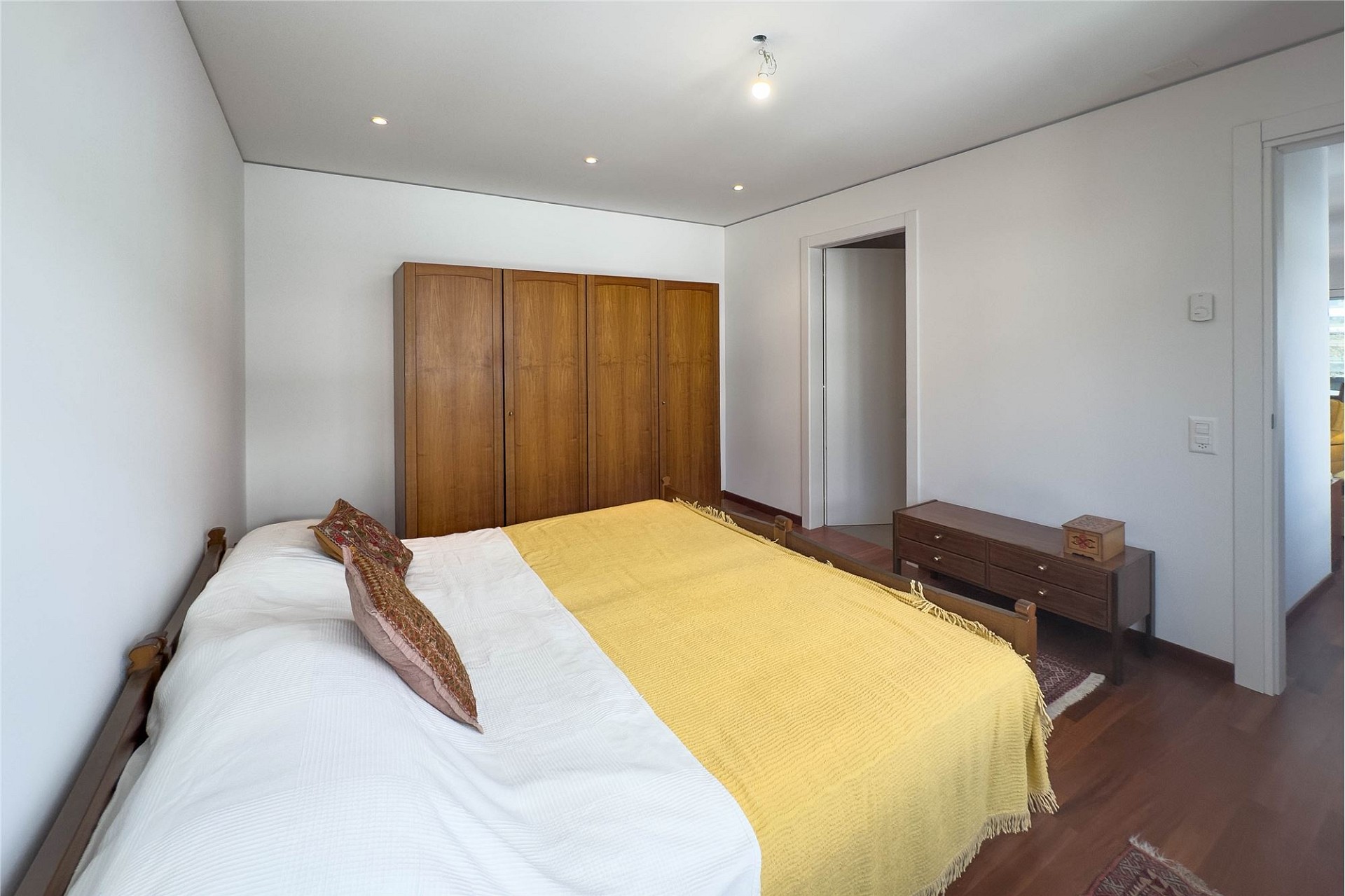 Schlafzimmer mit Doppelbett und Holzschrank