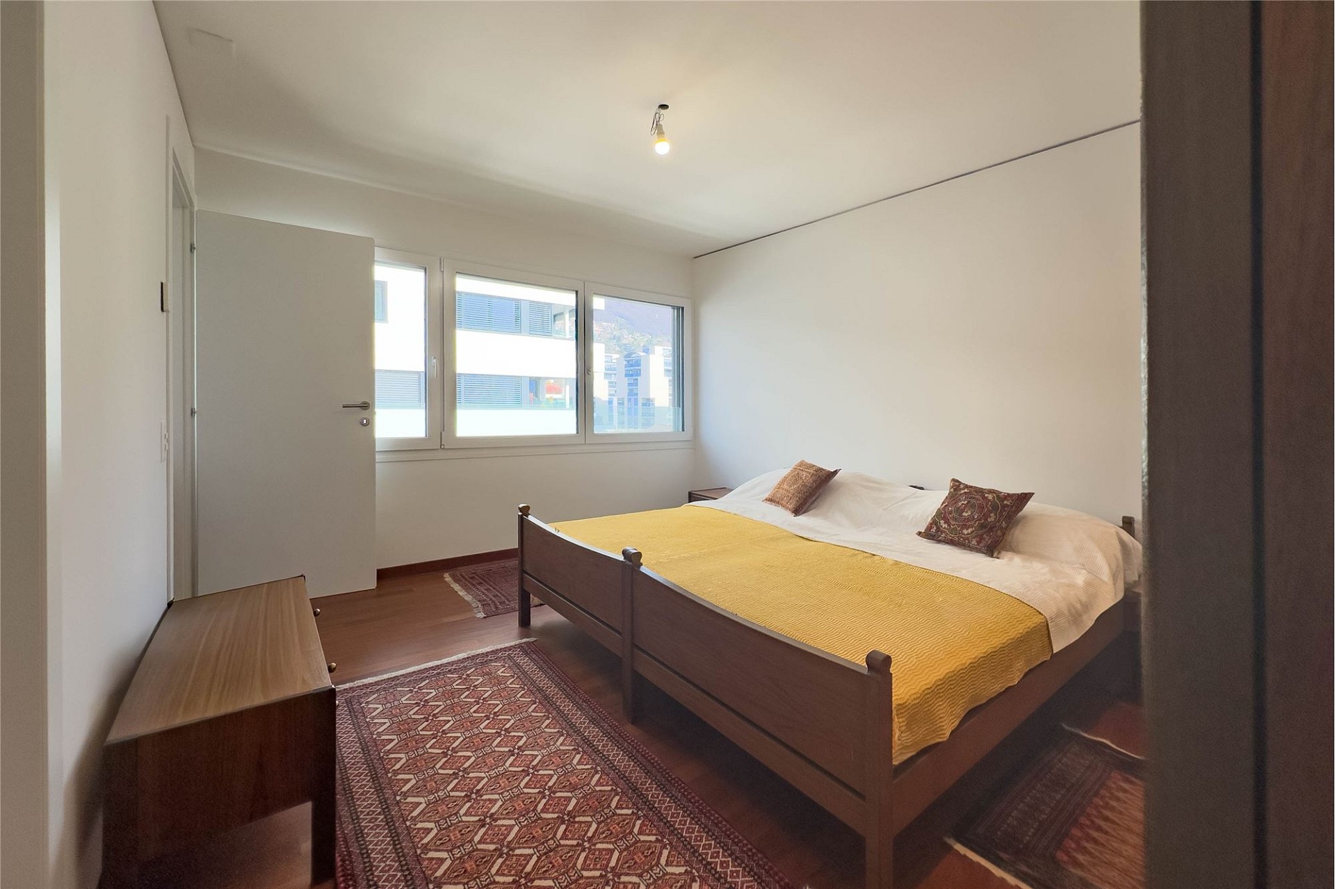 Schlafzimmer mit Bett und Fensterfront