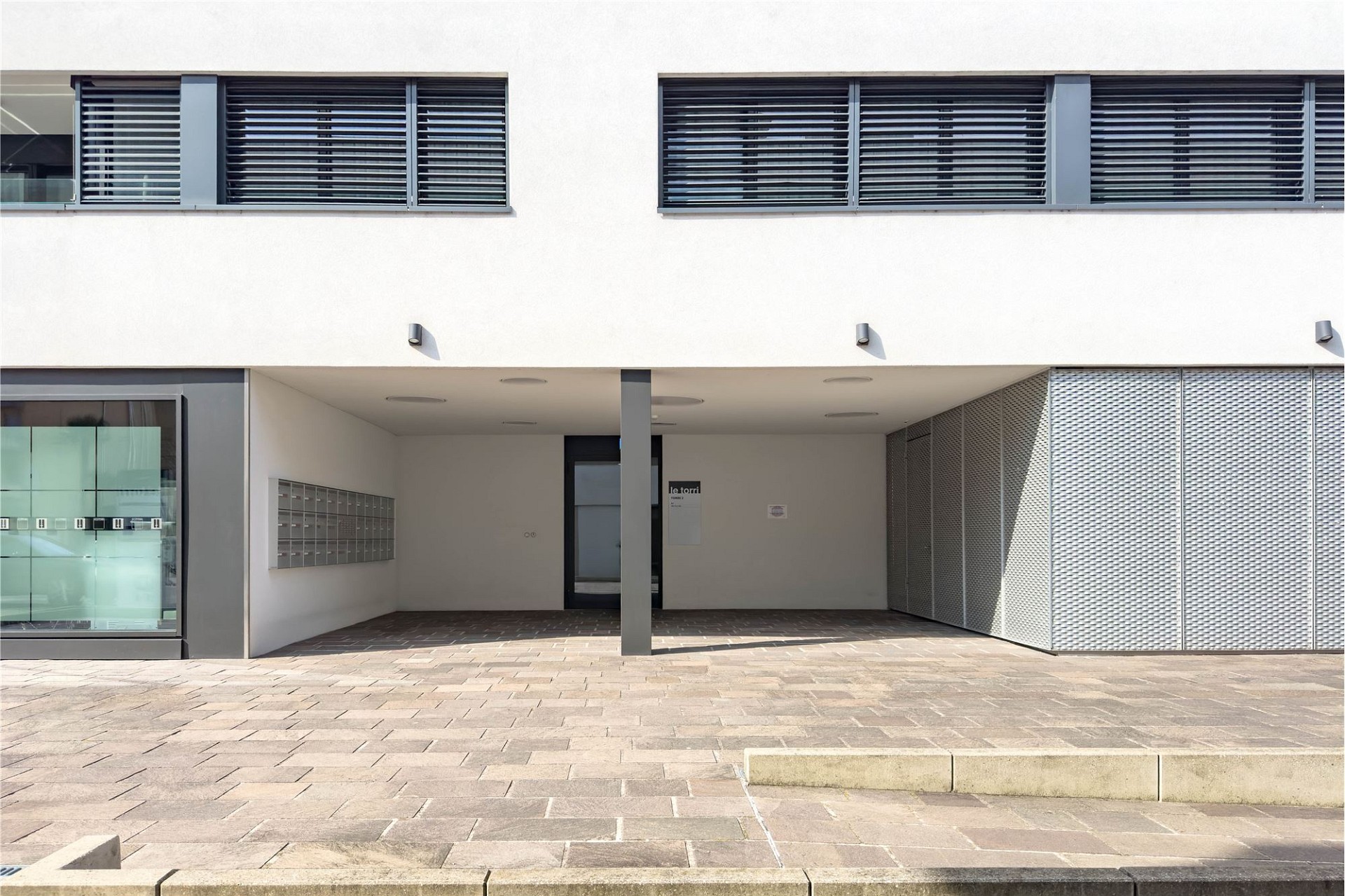 Moderner Gebäudeeingang mit überdachtem Vorbereich