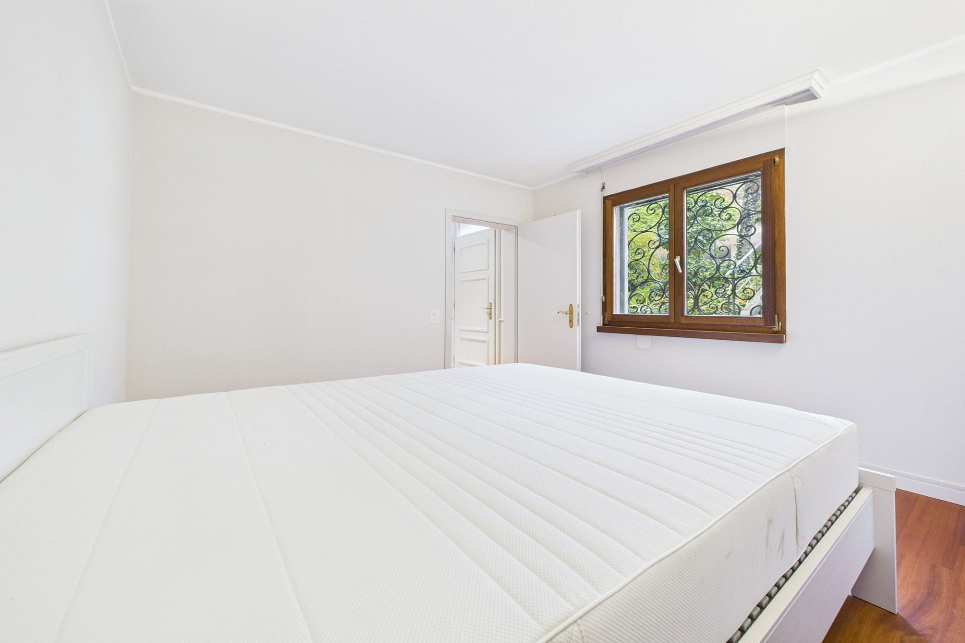 Helles Schlafzimmer mit schlichtem Bett