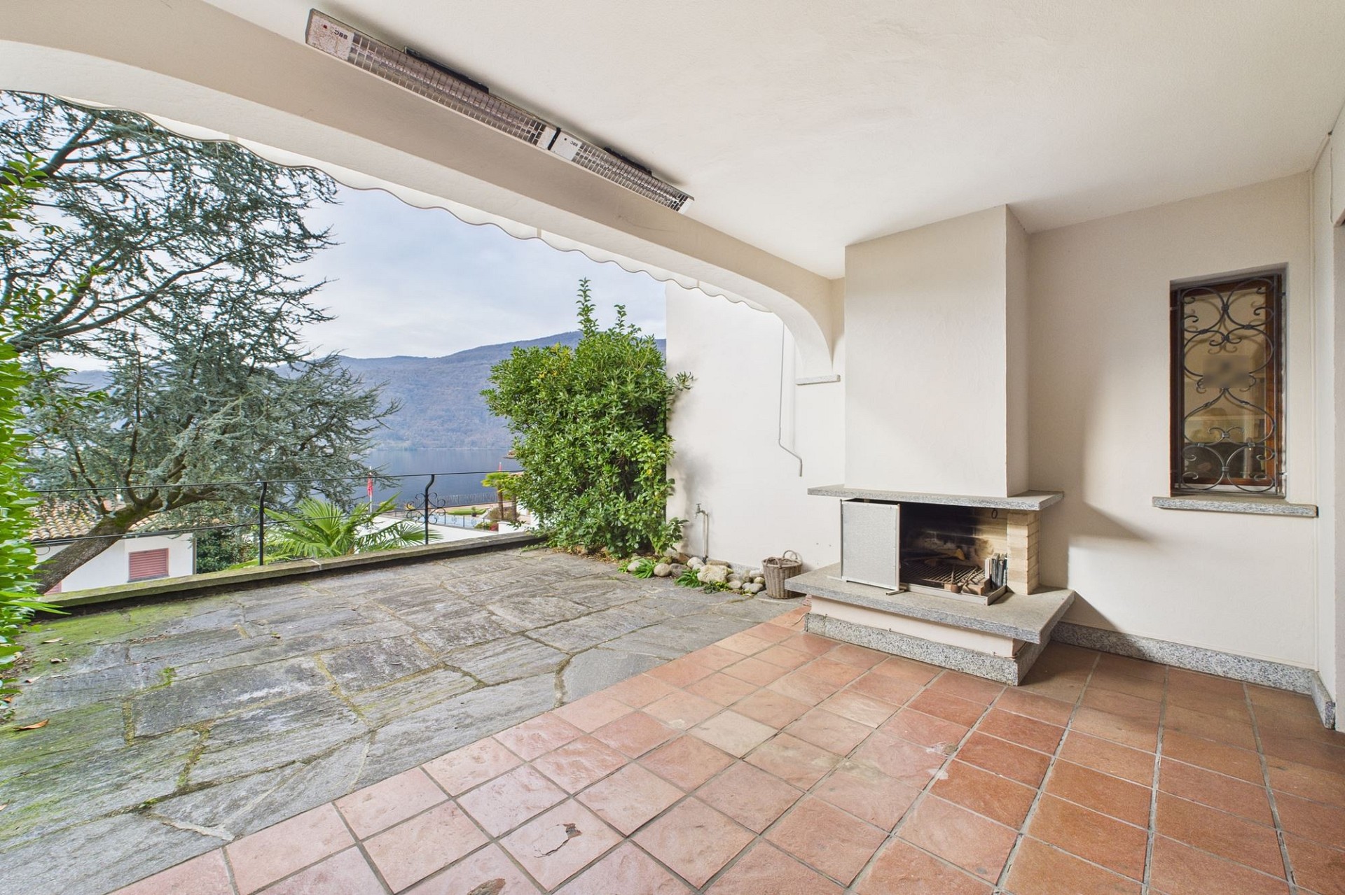 Überdachte Terrasse mit Blick auf See und Berge