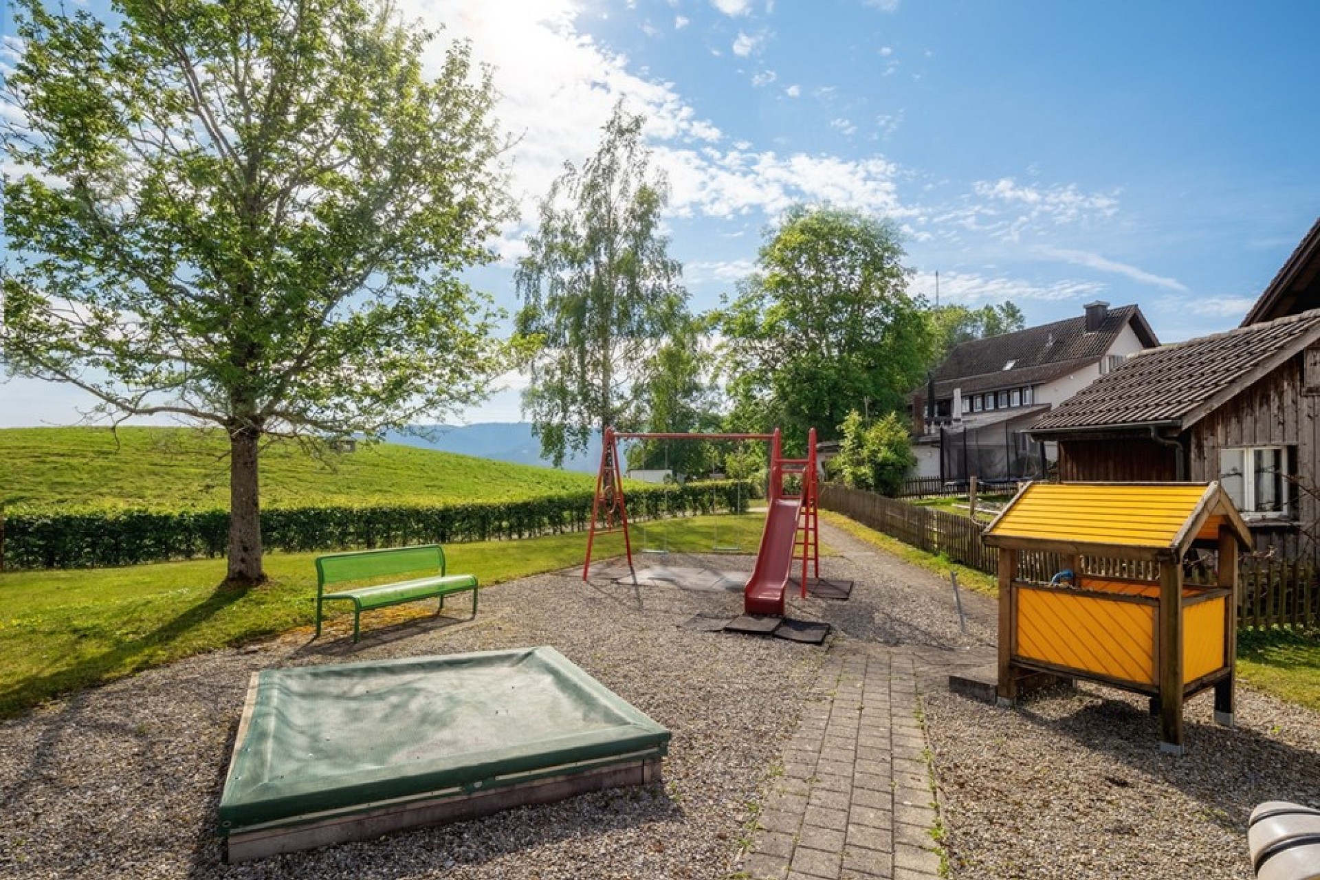 Außenbereich mit Spielplatz und Garten