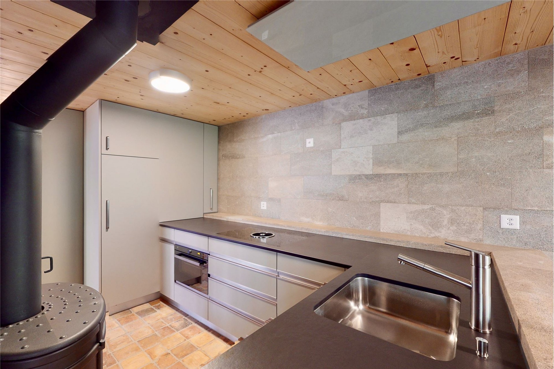 Moderne Küche mit Holzdecke und Steinwand