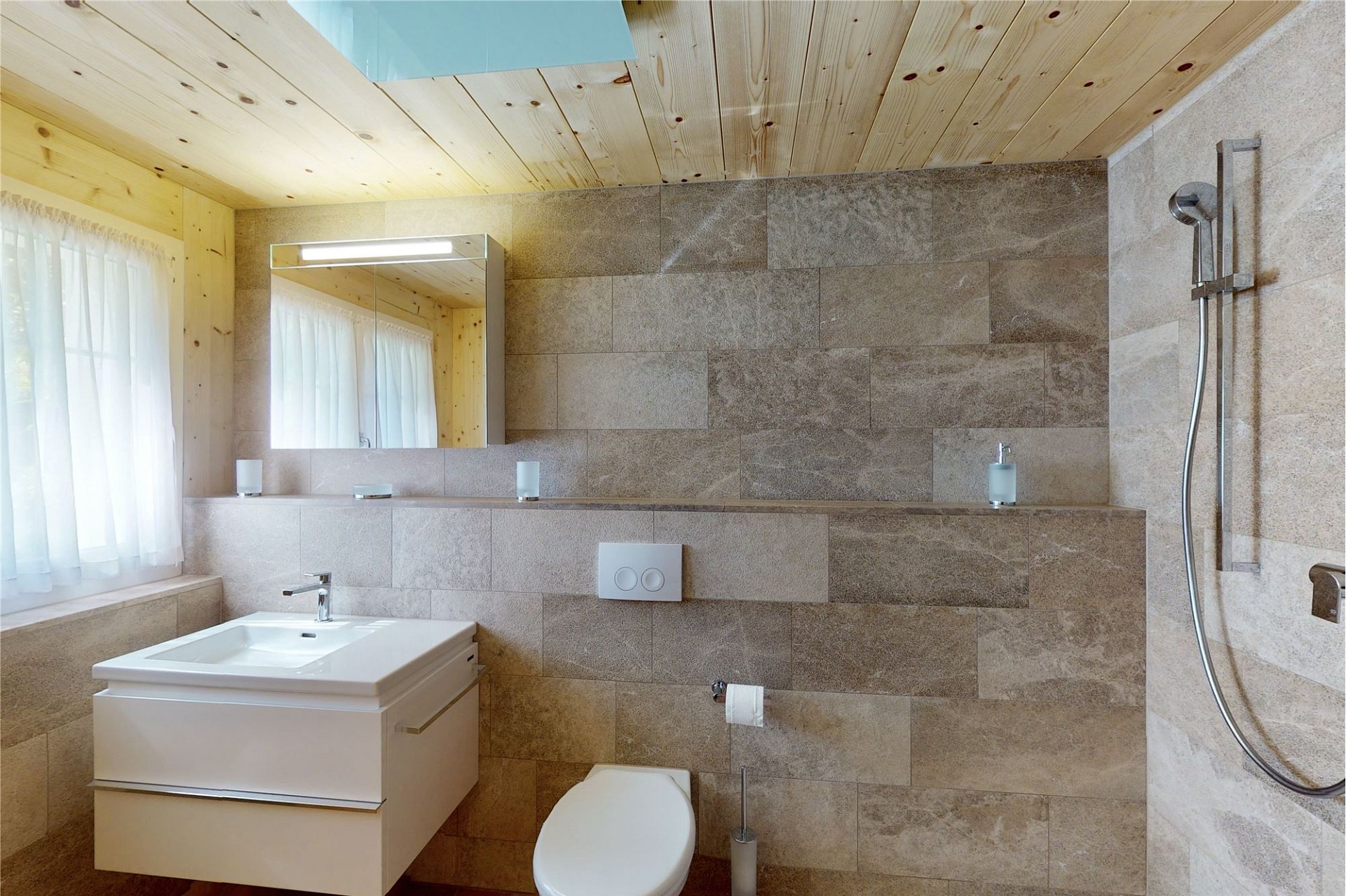 Helles Badezimmer mit Naturstein und Holzdecke