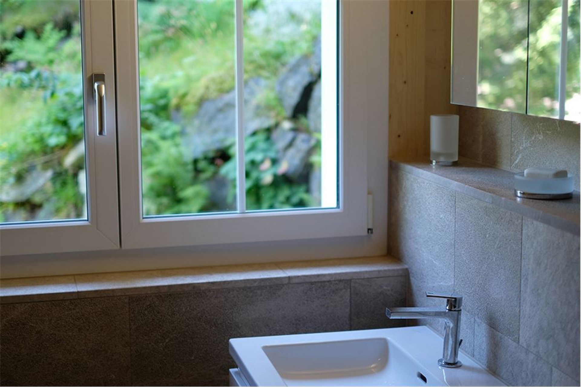 Helles Badezimmer mit Fenster und Naturblick