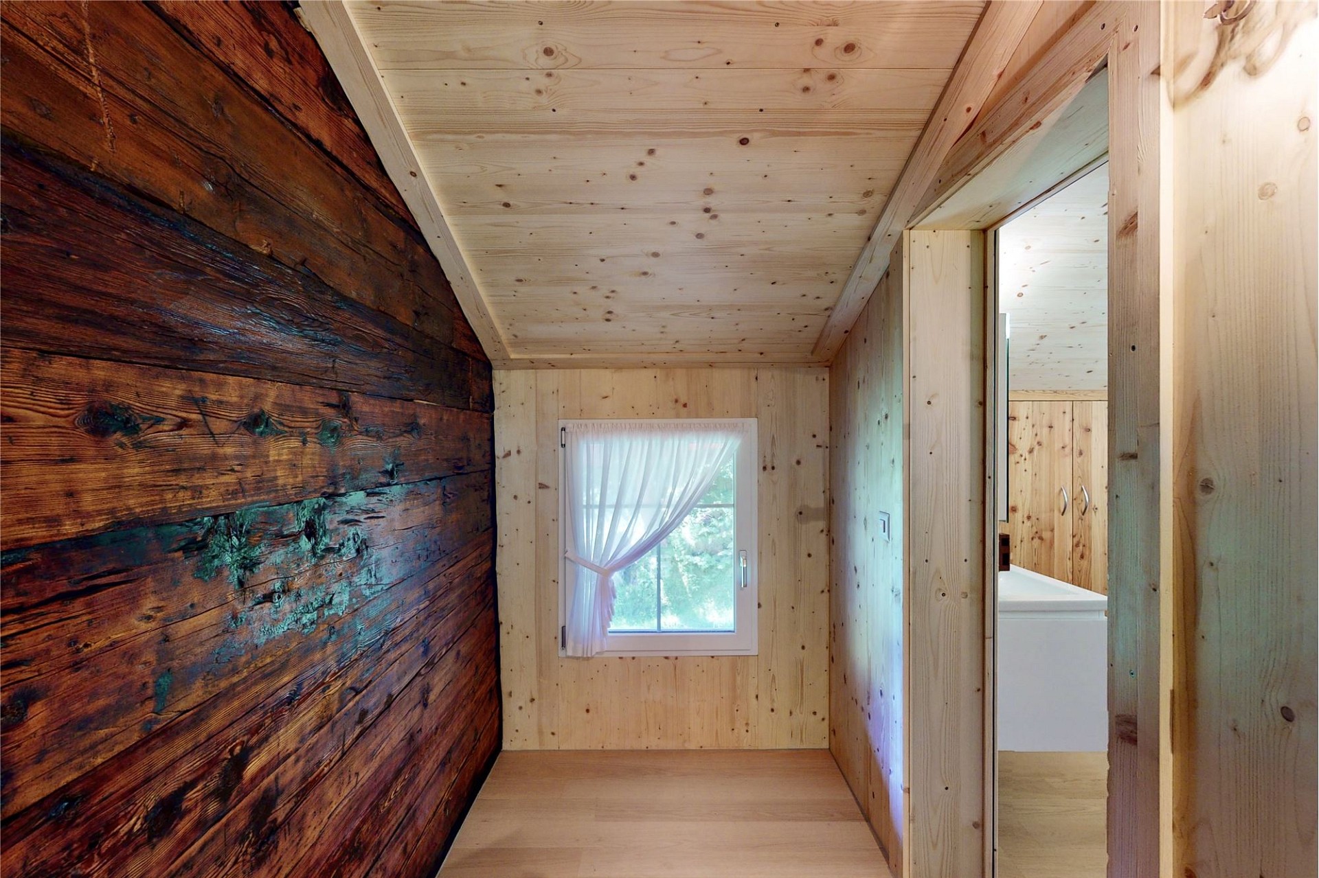 Holzverkleideter Innenraum mit kleinem Fenster