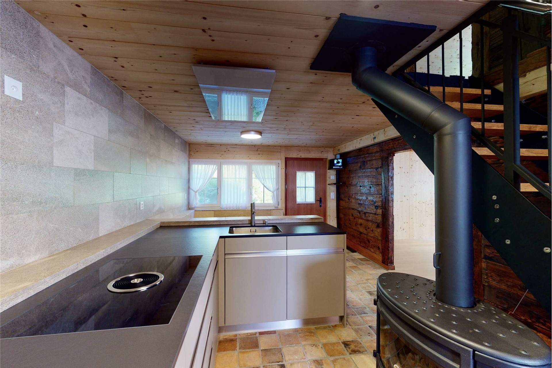 Offene Küche mit Holzdecke und Kaminofen