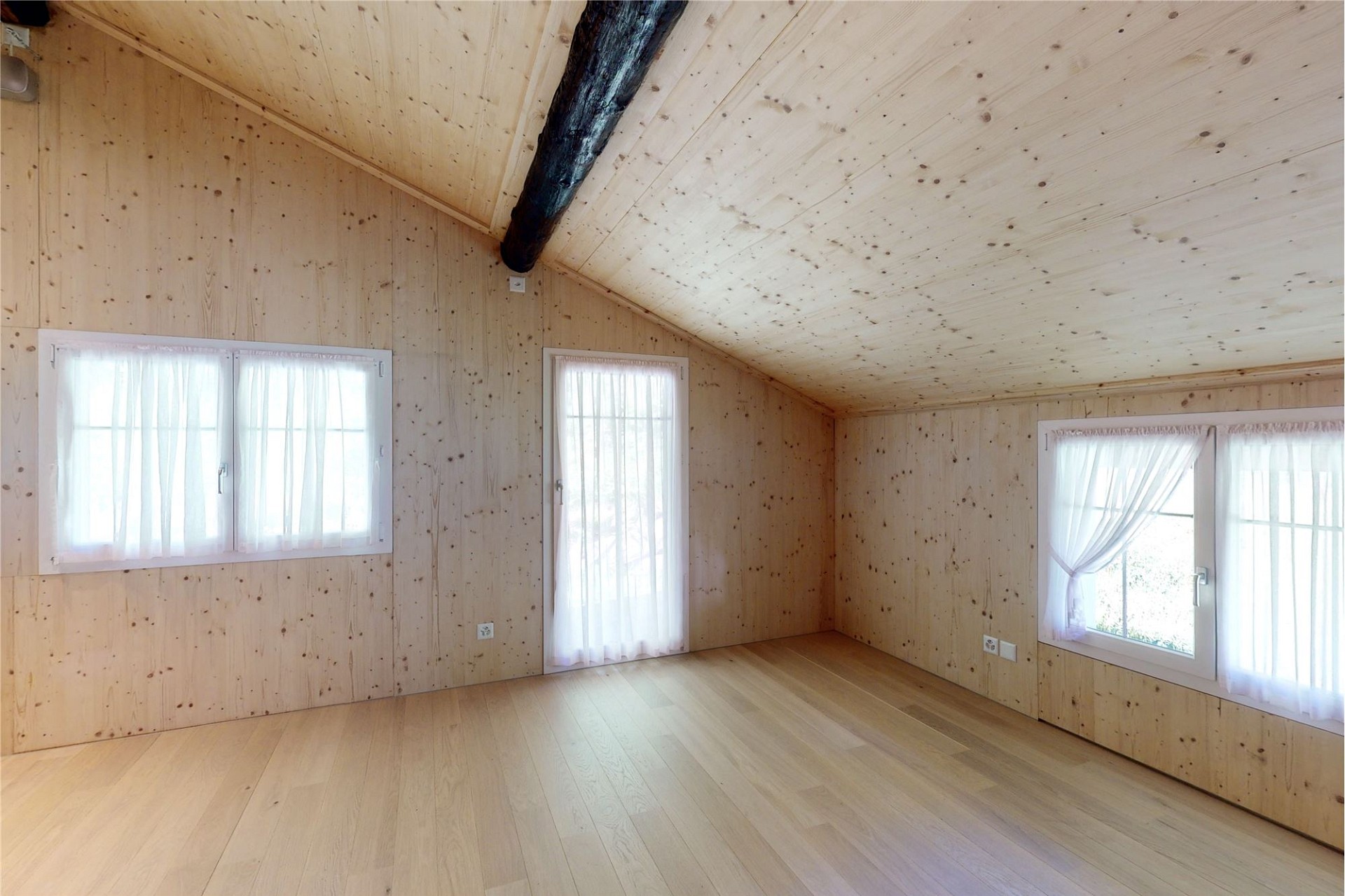 Heller leerer Dachgeschossraum mit Holzverkleidung