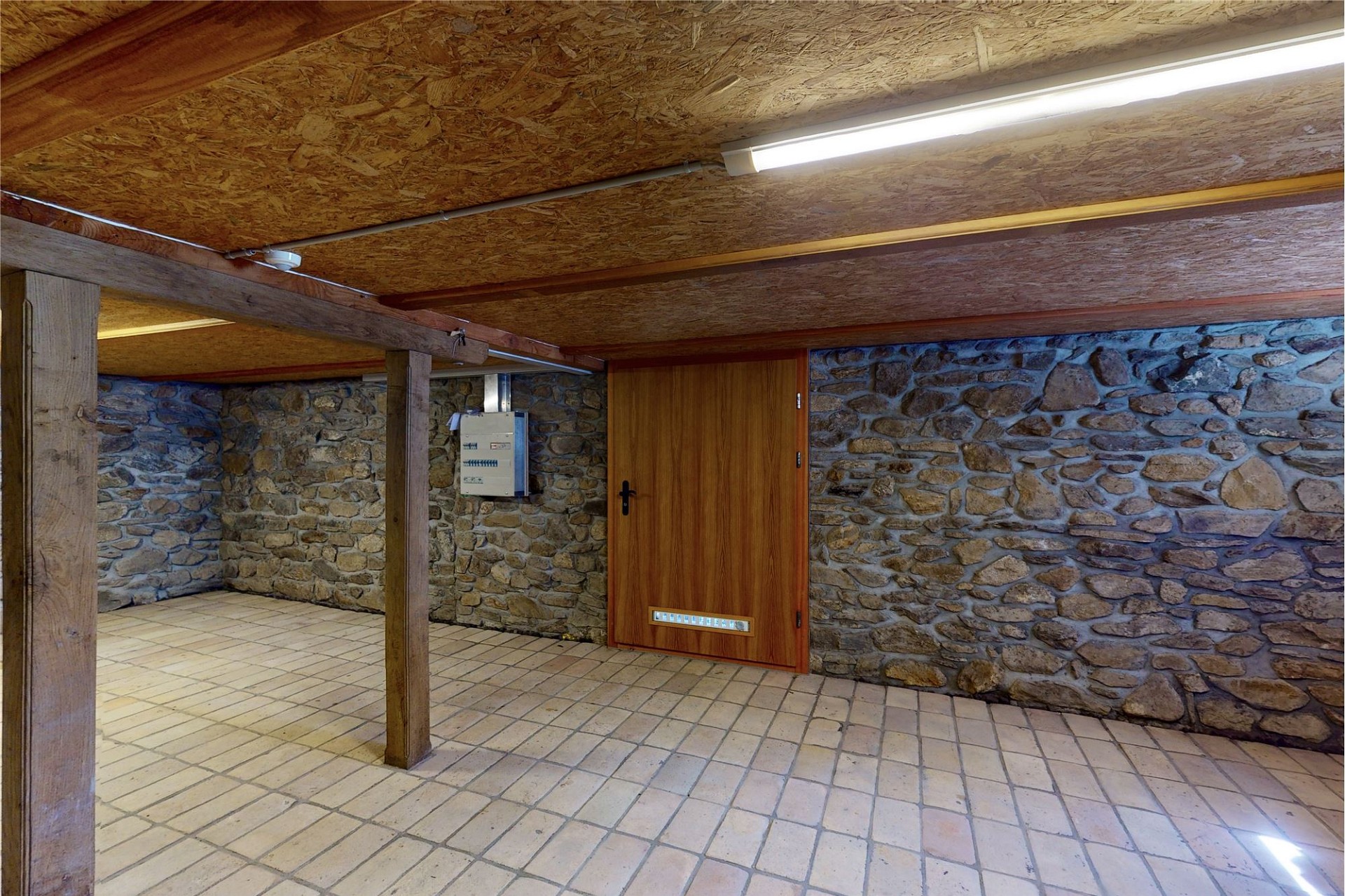 Kellerraum mit Natursteinwänden und Holztür