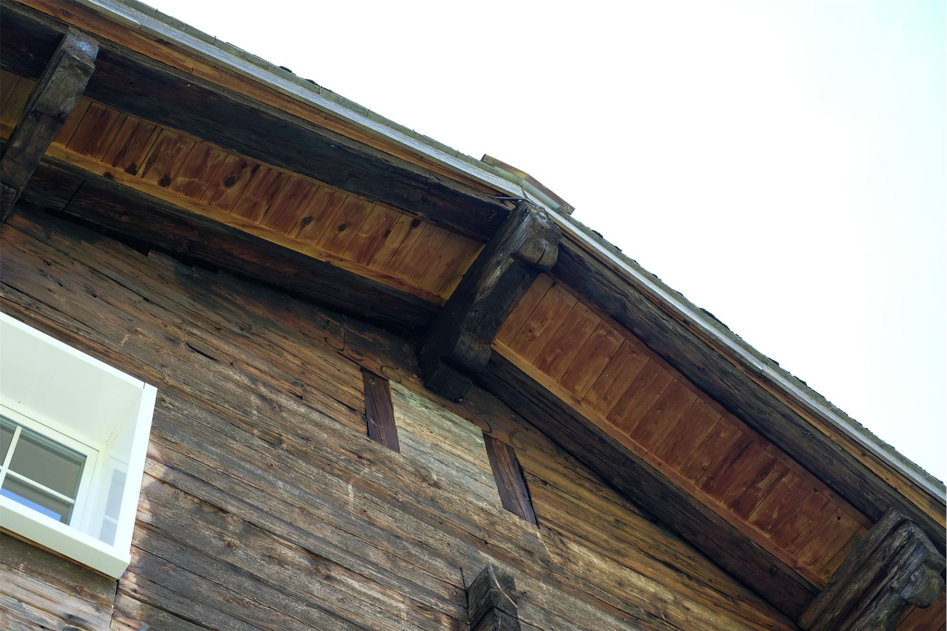 Rustikale Holzfassade unter dem Dachvorsprung