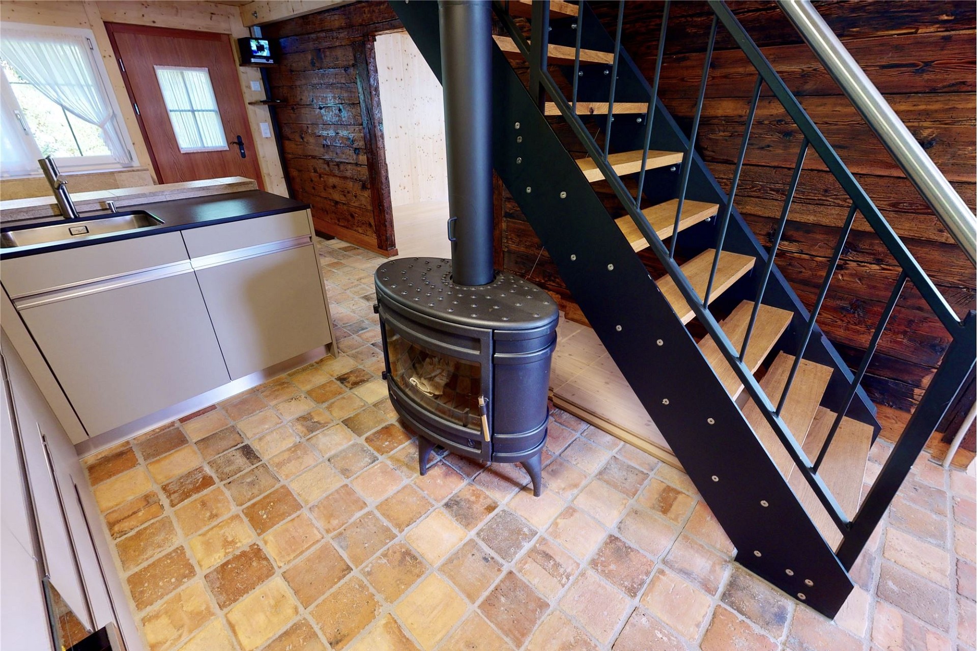 Gemütlicher Innenraum mit Holzofen und Treppe