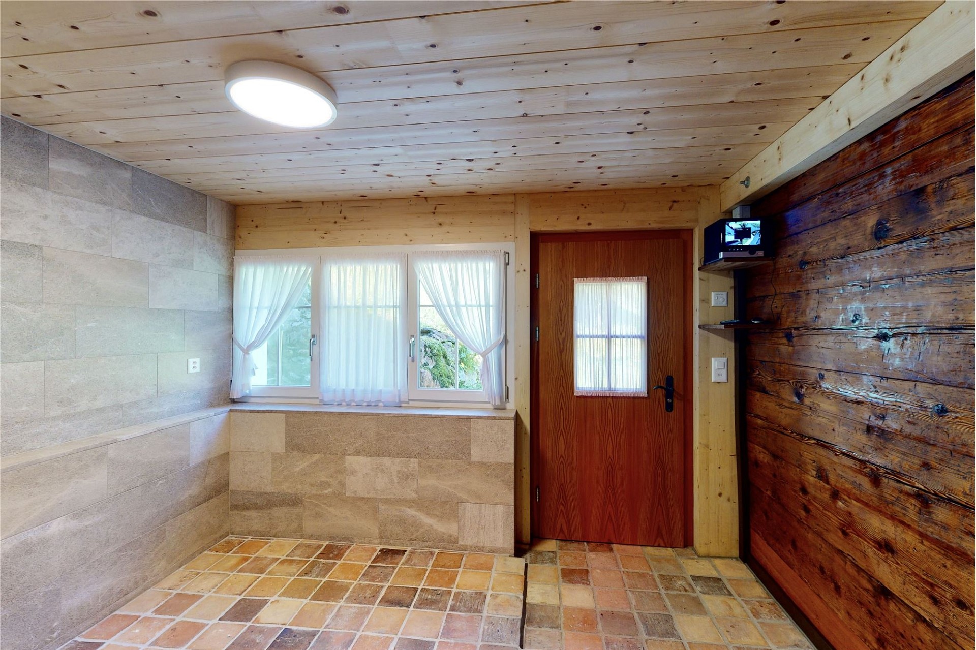 Rustikaler Eingangsbereich mit Holz, Stein und Terrakotta