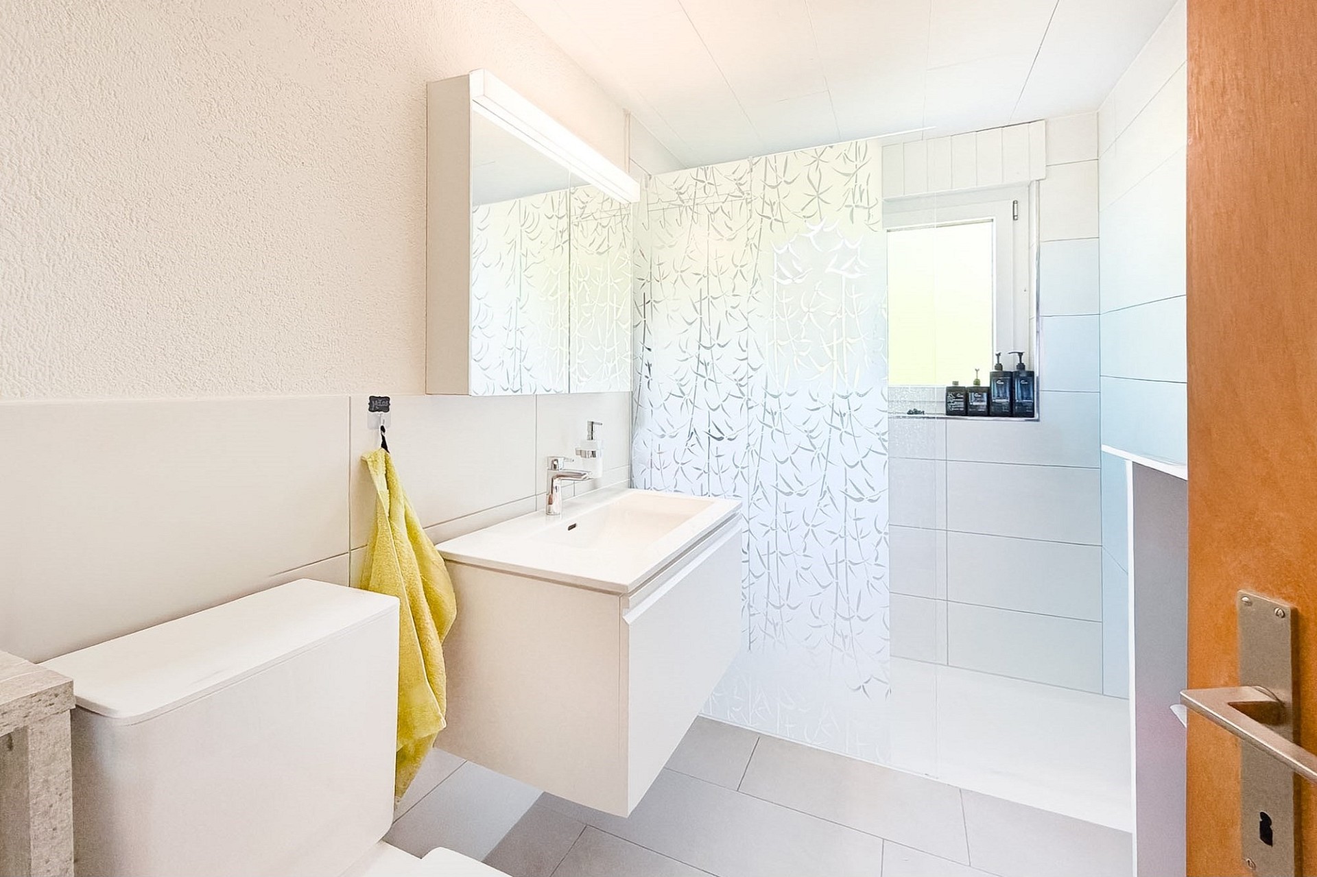 Helles Badezimmer mit Waschplatz und Dusche