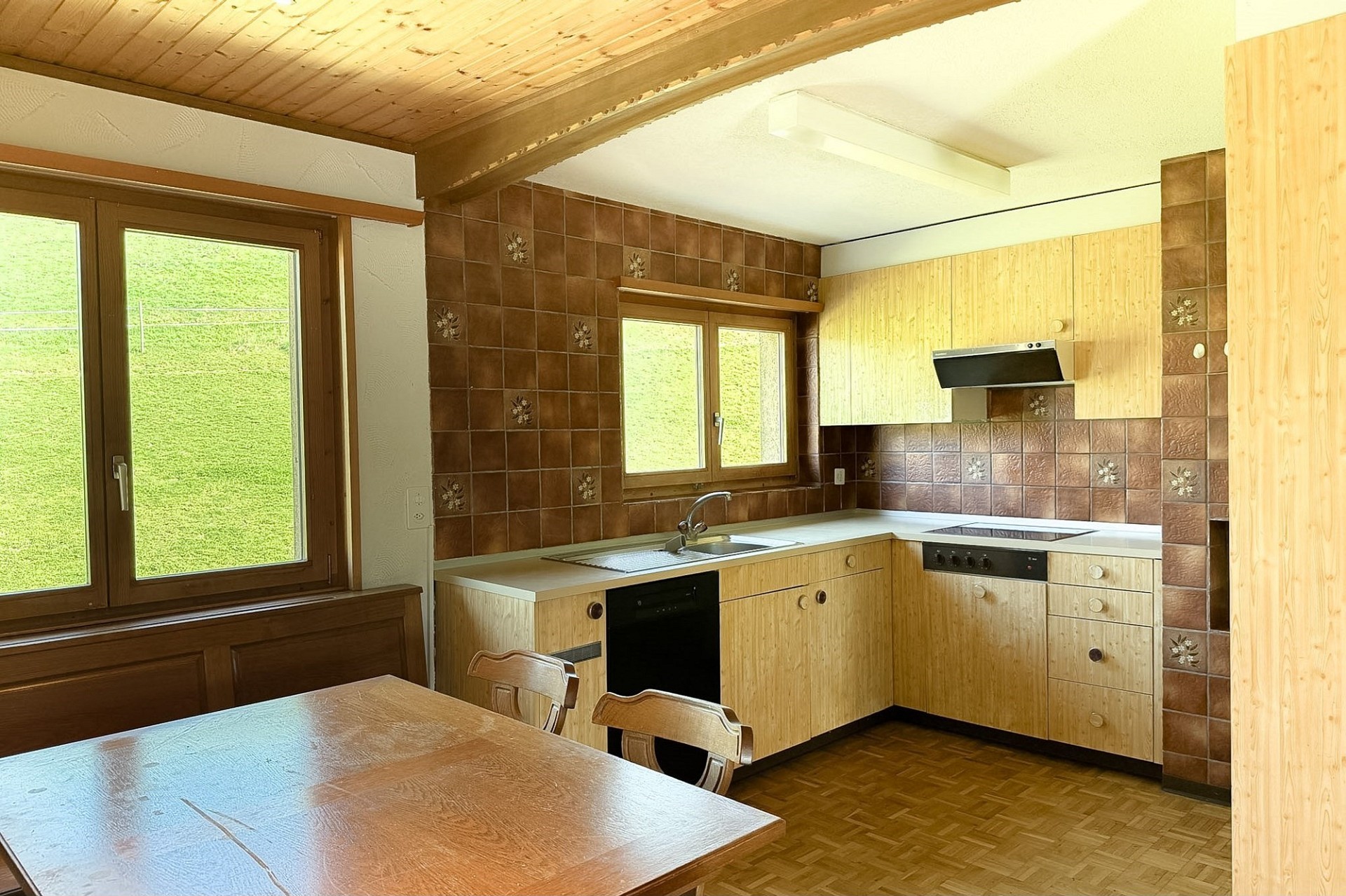 Küche mit Holzdecke und Blick ins Grüne