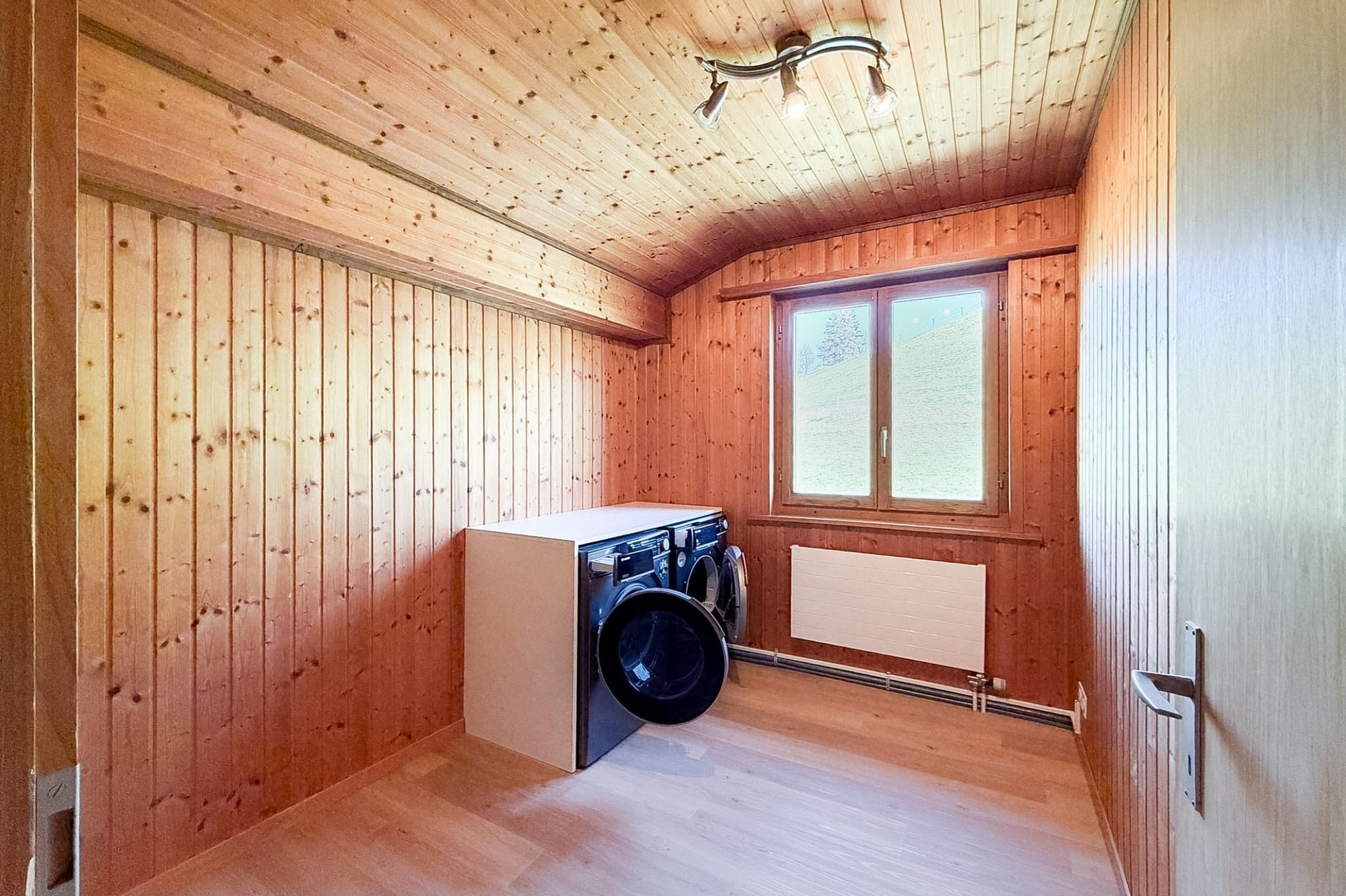 Holzverkleideter Hauswirtschaftsraum mit Waschmaschine und Trockner