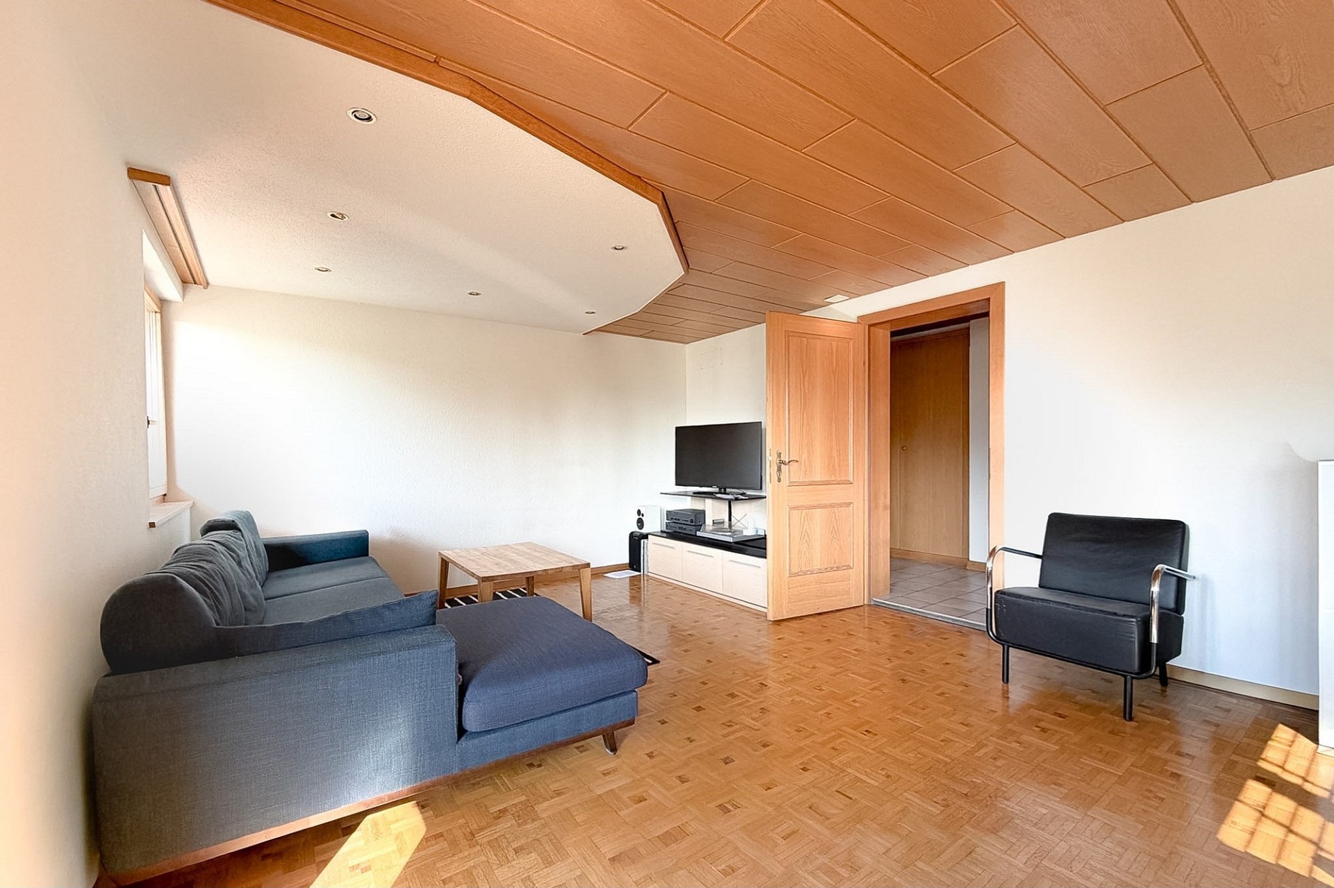 Wohnzimmer mit Holzboden und Holzdecke