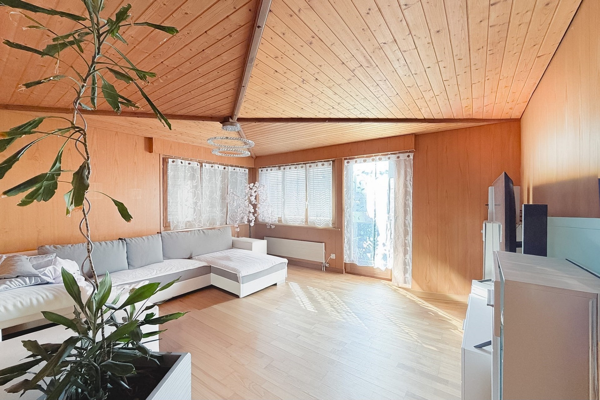 Helles Wohnzimmer mit Holzvertäfelung und Dachschräge