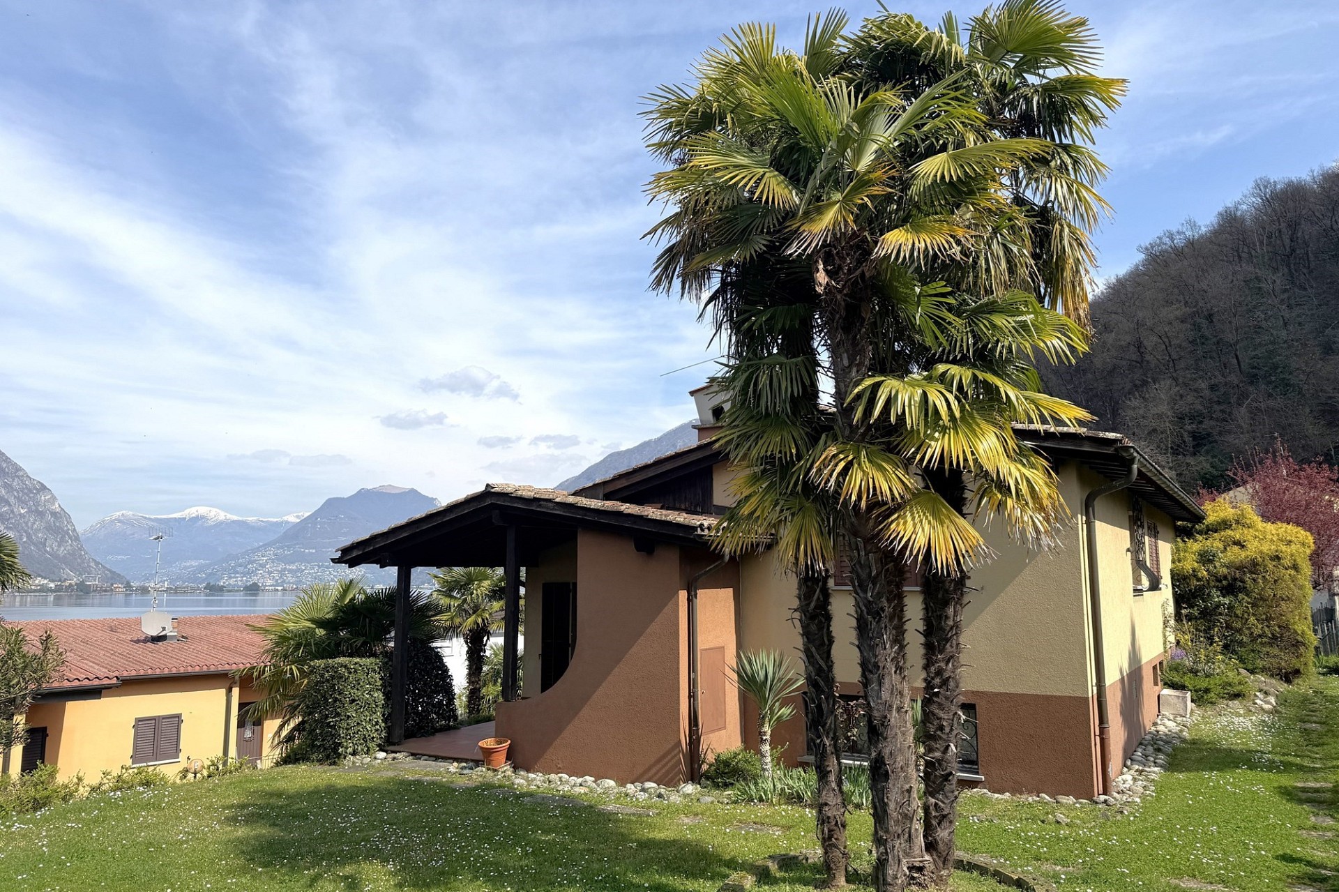 Außenansicht eines Hauses am See mit Bergkulisse