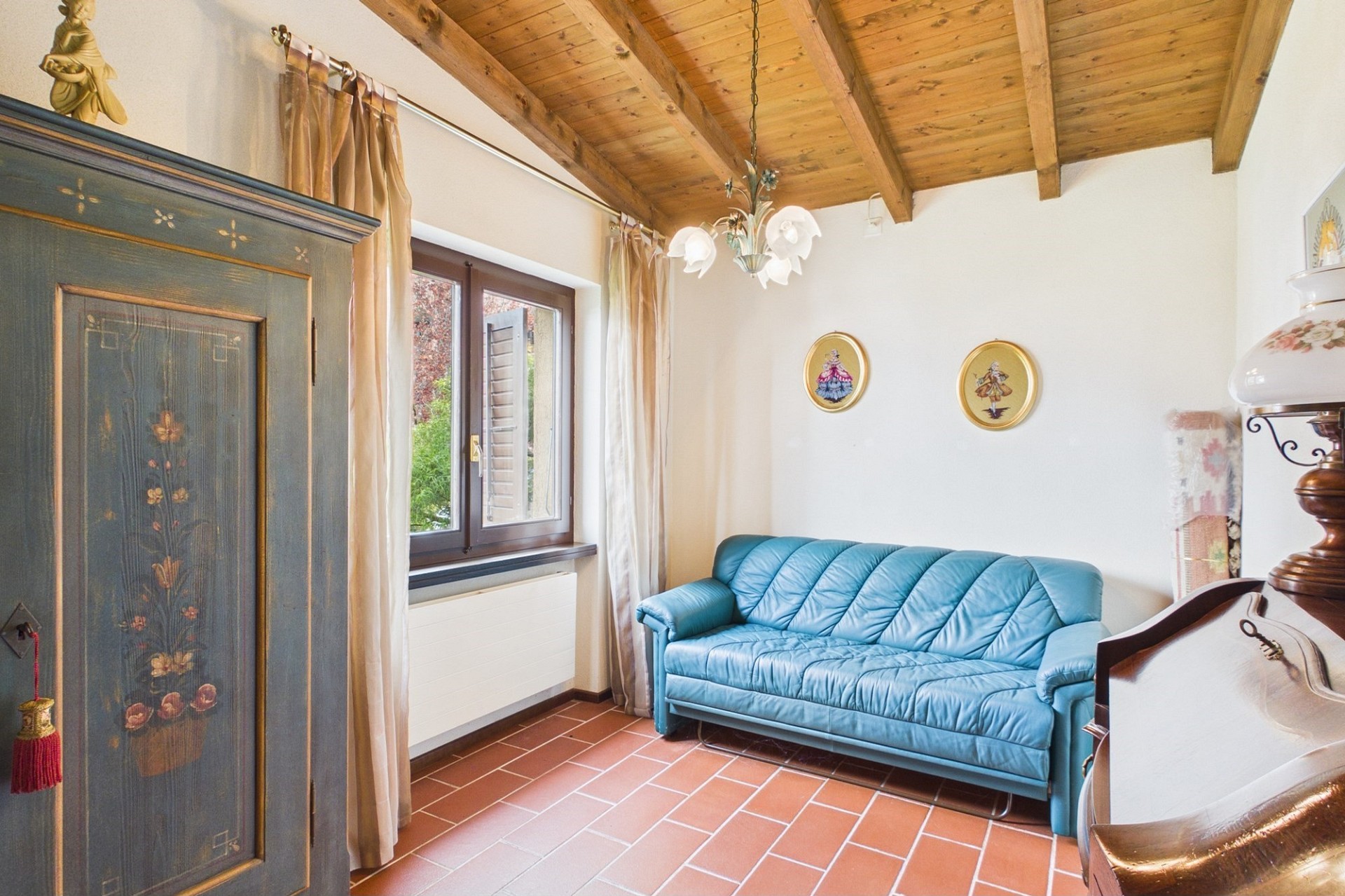 Gemütliches Zimmer mit Holzbalkendecke und Sofa