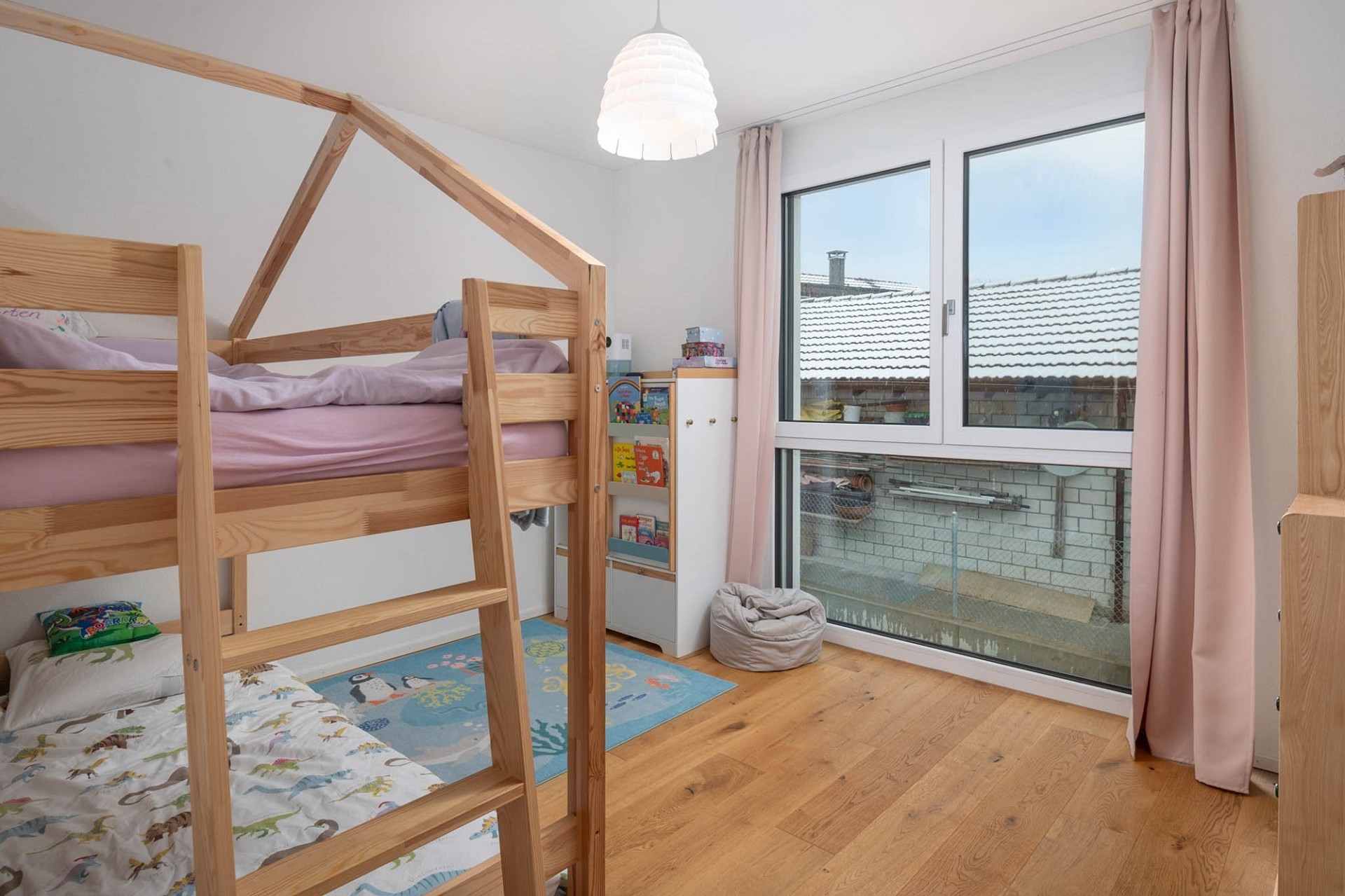 Kinderzimmer mit Hochbett und großem Fenster