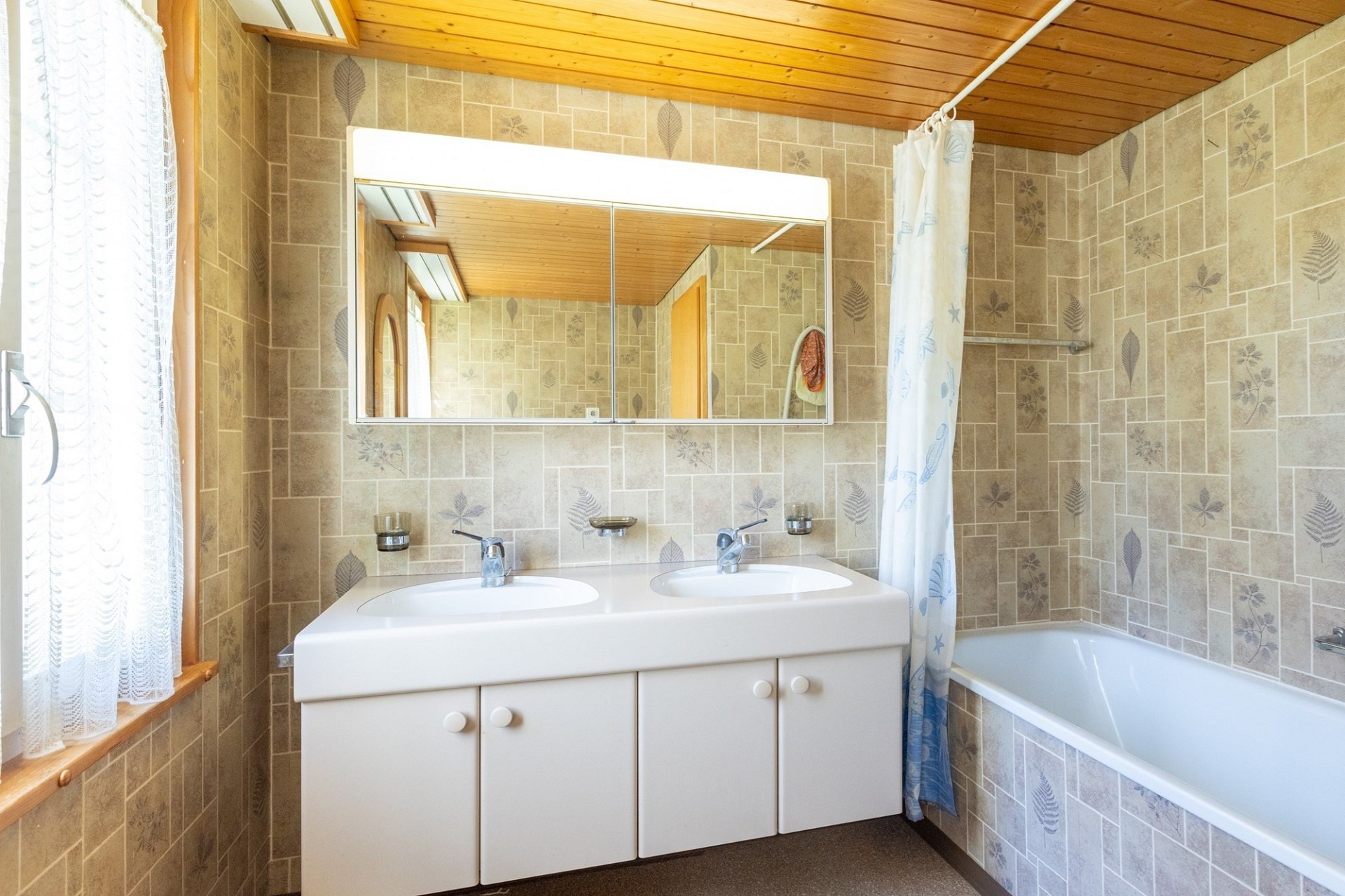 Badezimmer mit Doppelwaschtisch und Badewanne