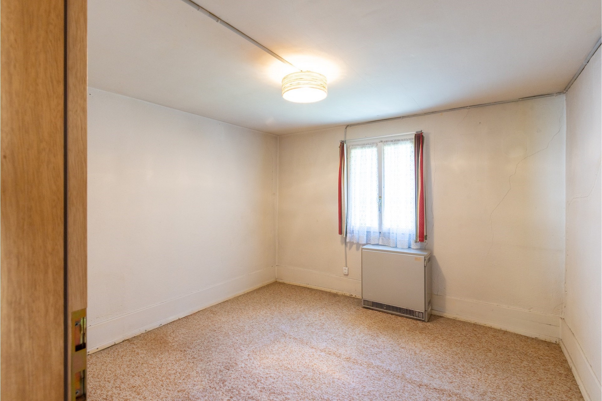 Einfache, leerstehende Innenraumaufnahme mit Fenster und Heizkörper