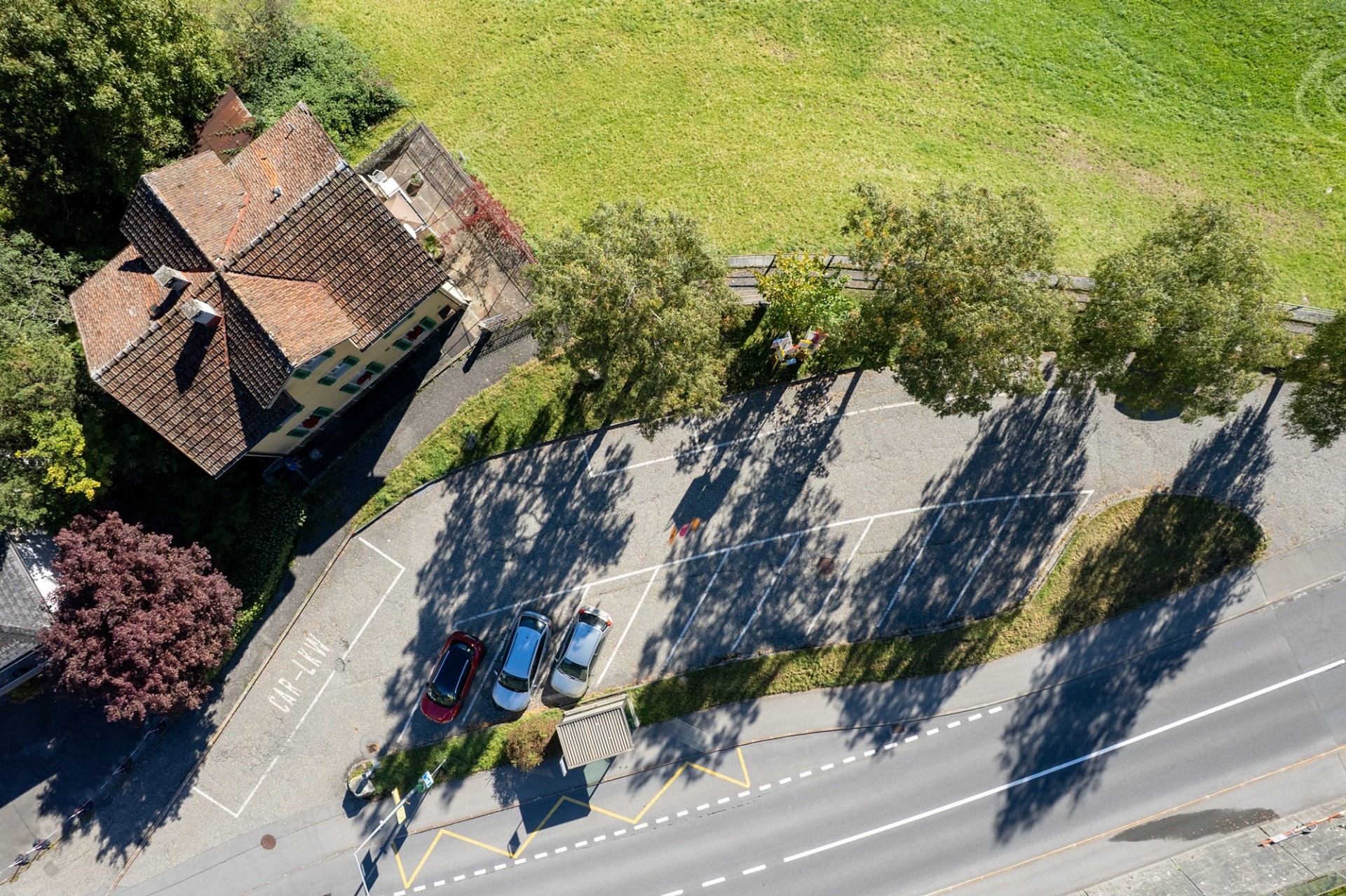 Luftaufnahme eines Hauses mit Straße und Parkplatz