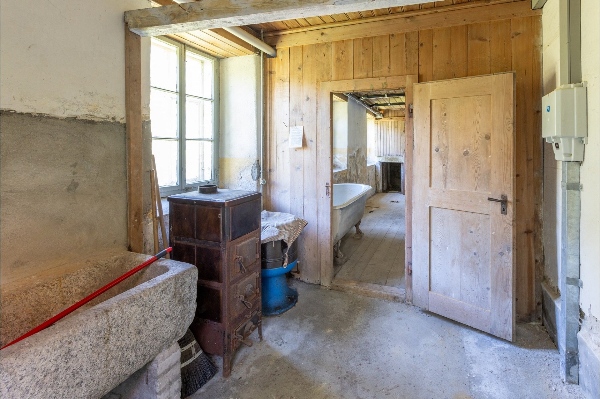 Rustikaler Nutzraum mit Badewanne und Holzvertäfelung