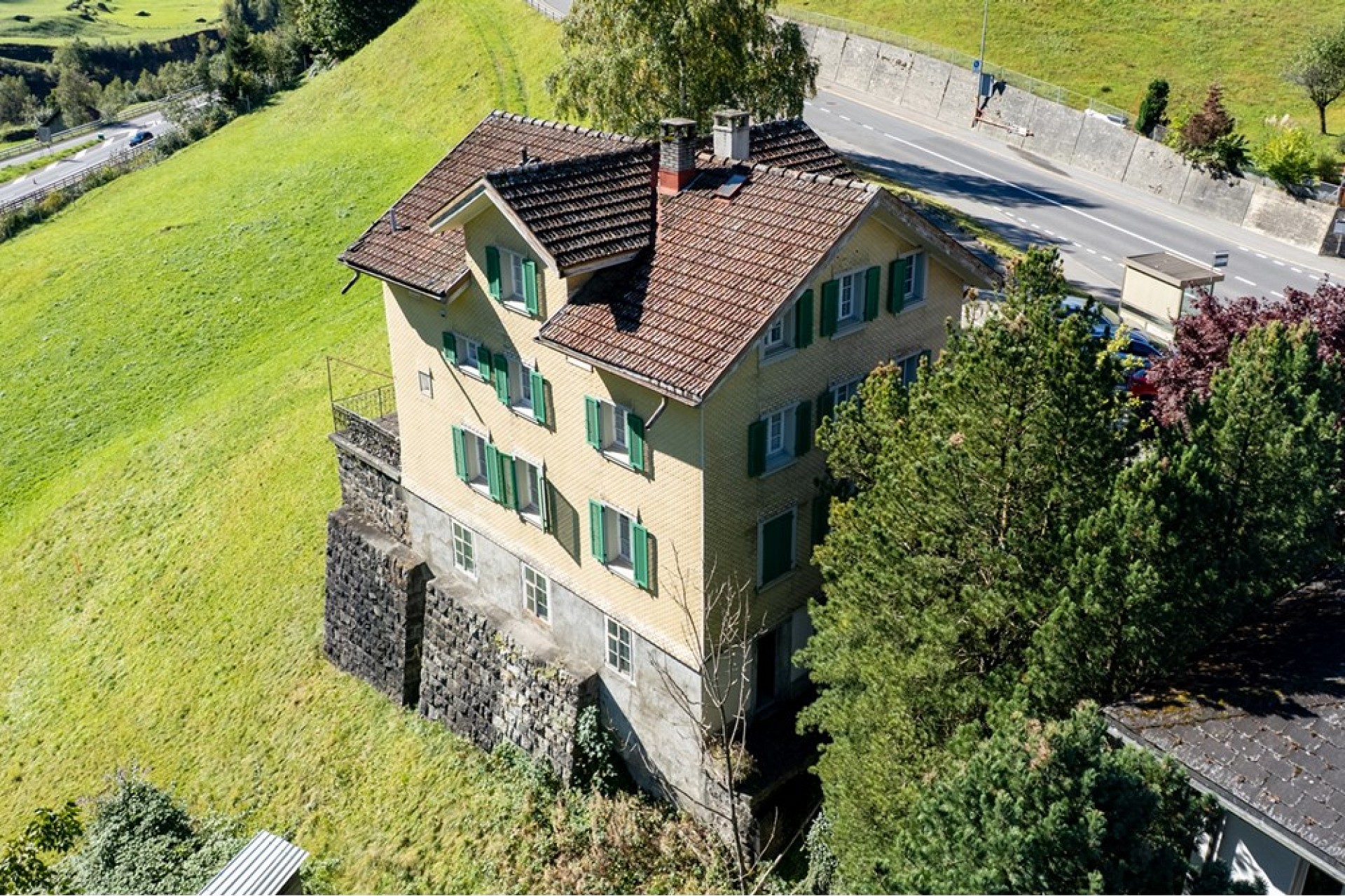Luftaufnahme eines ländlich gelegenen Hauses am Hang