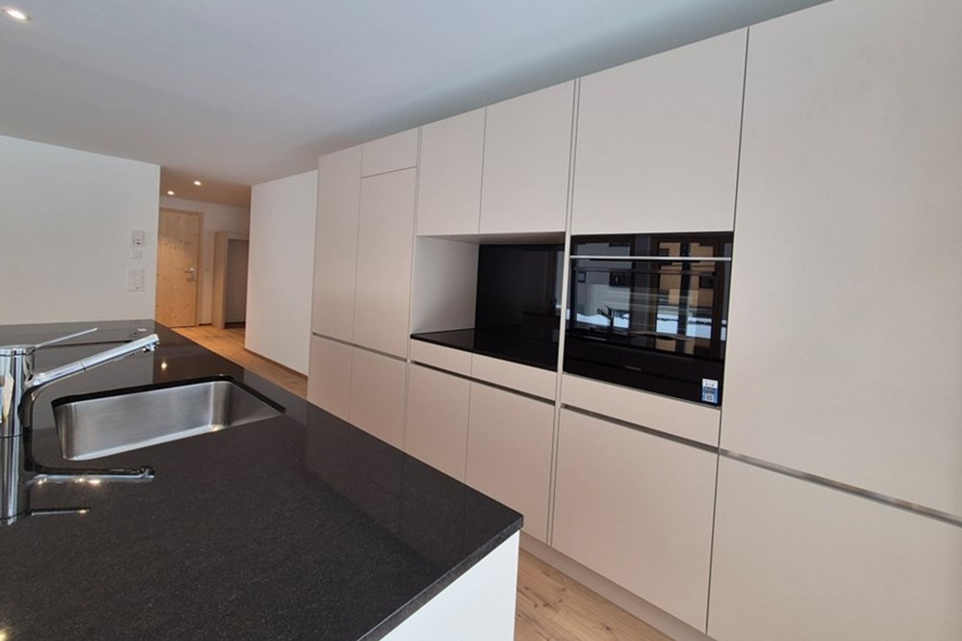 Moderne Einbauküche mit schwarzer Arbeitsplatte