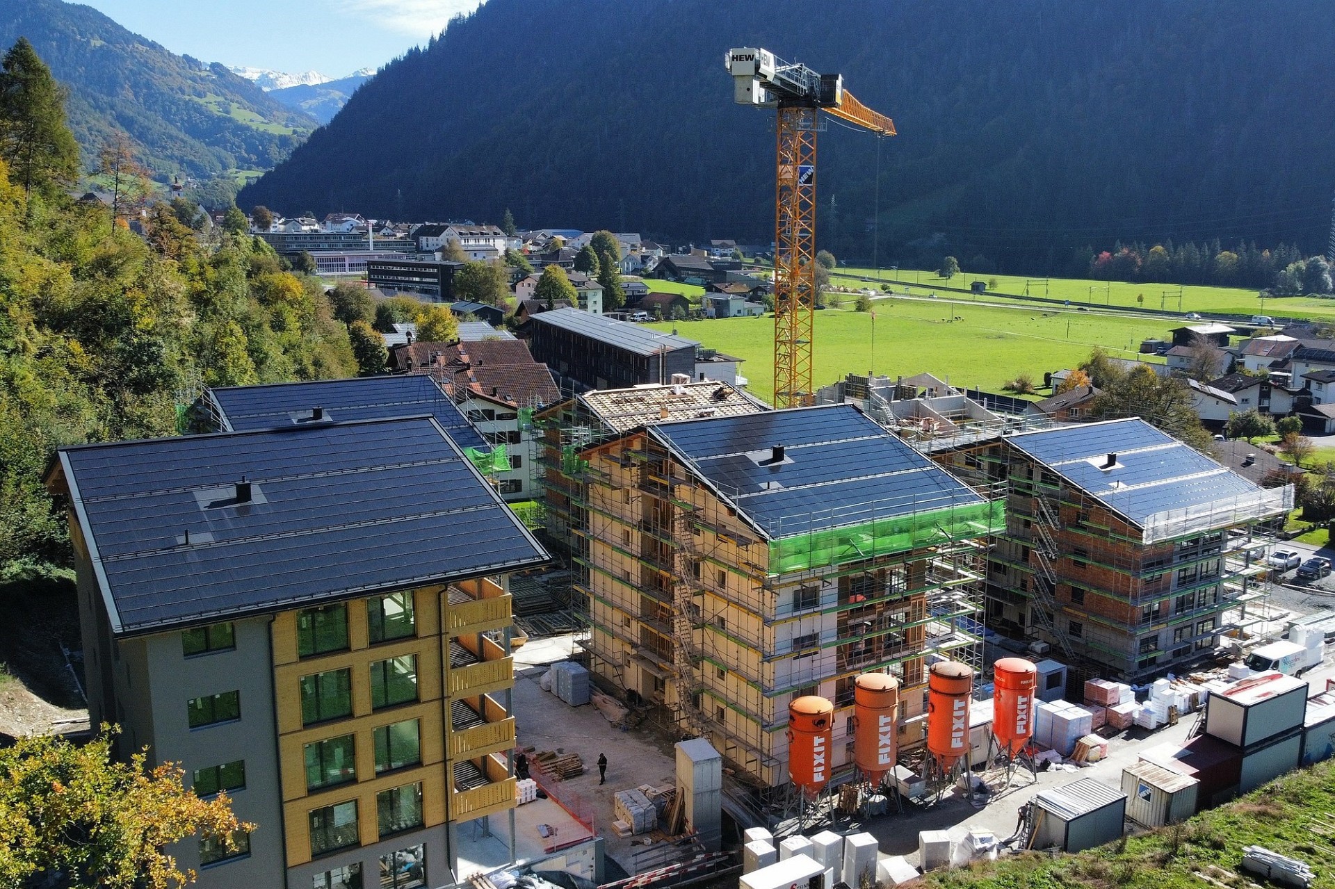 Luftaufnahme einer Wohnanlage im Bau in einem alpinen Tal
