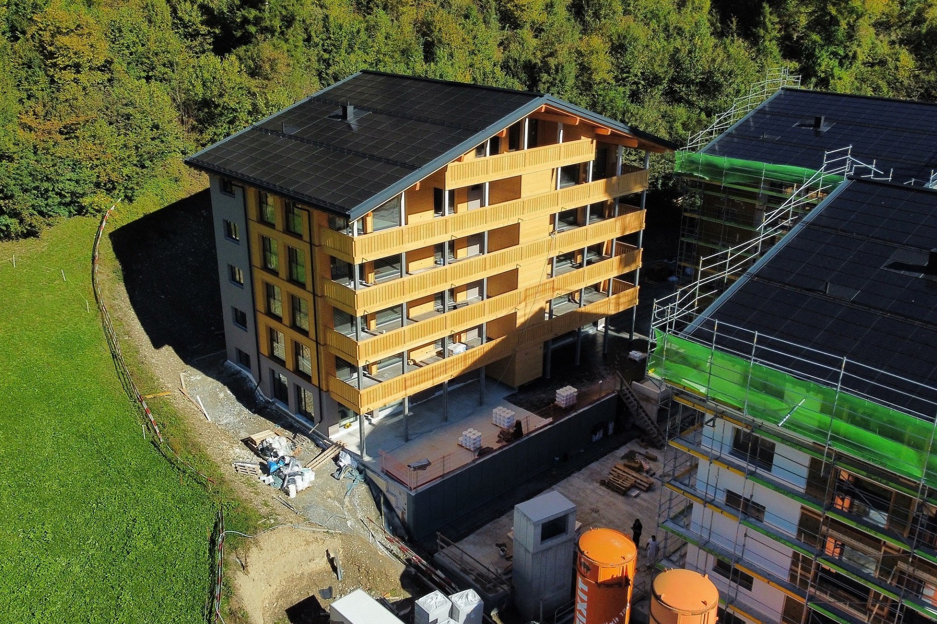 Mehrfamilienhaus im Bau mit Holzfassade und Solardach