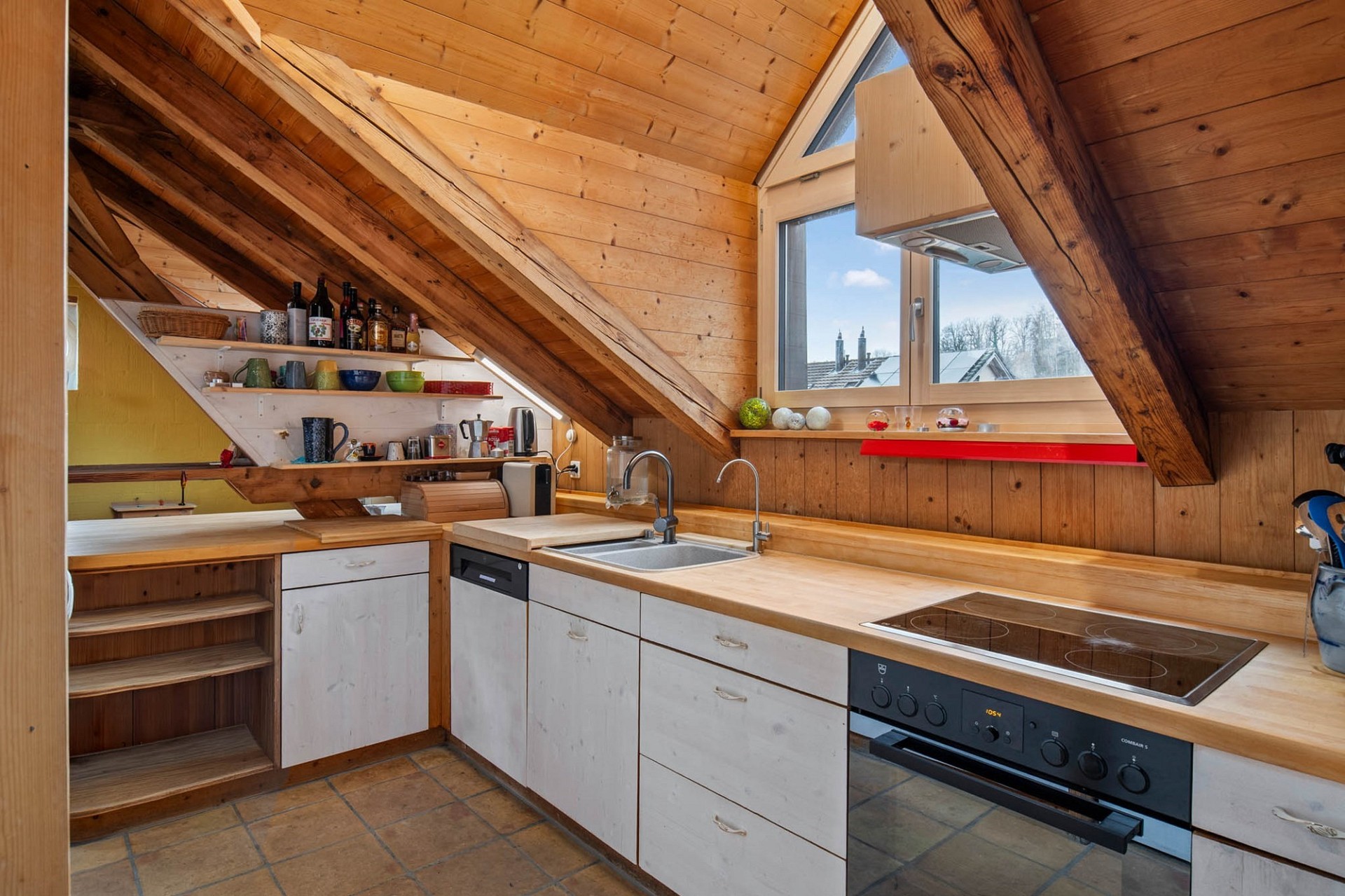 Dachgeschossküche mit sichtbaren Holzbalken