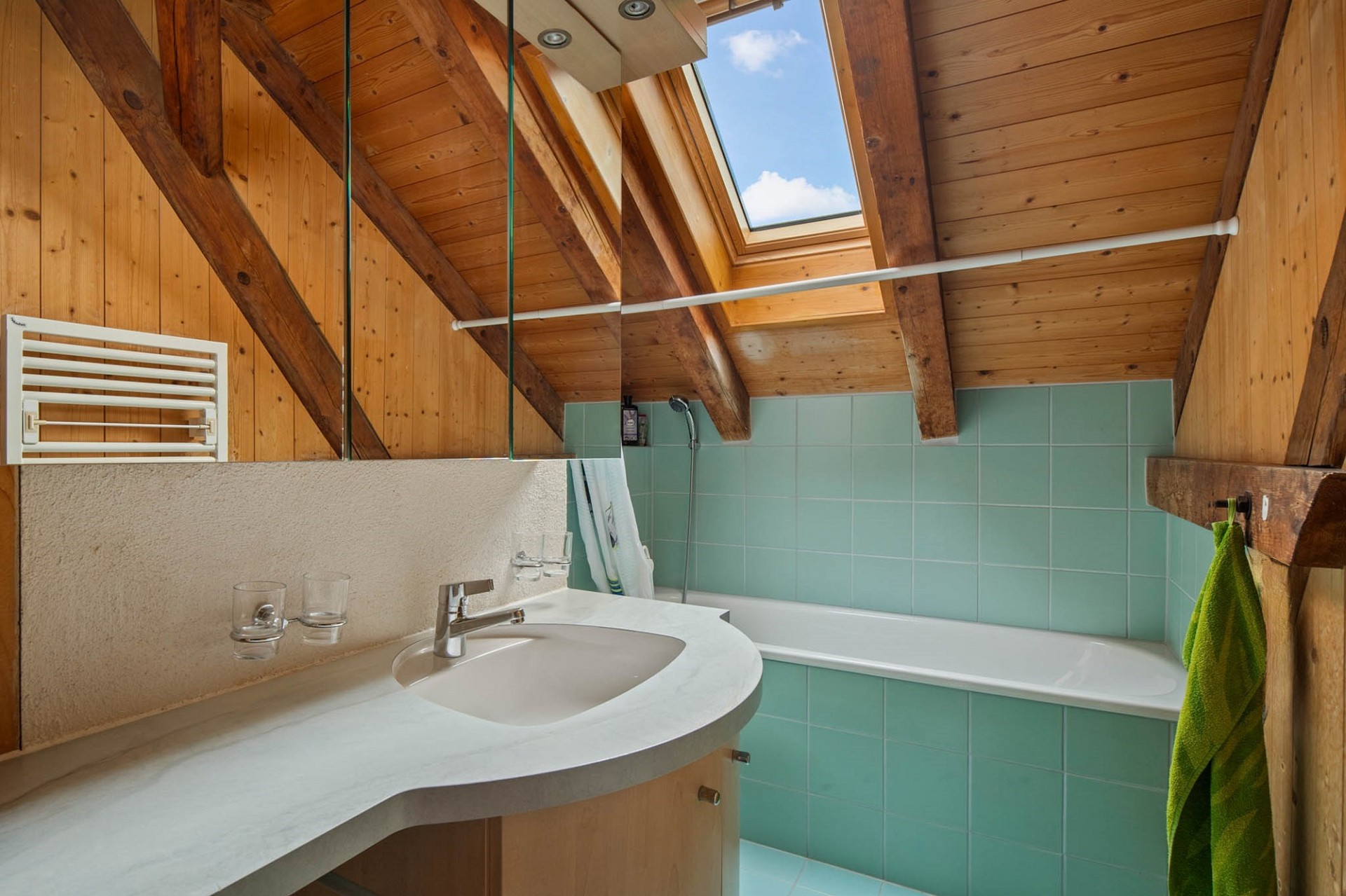 Dachgeschoss-Badezimmer mit Holz und türkisfarbenen Fliesen