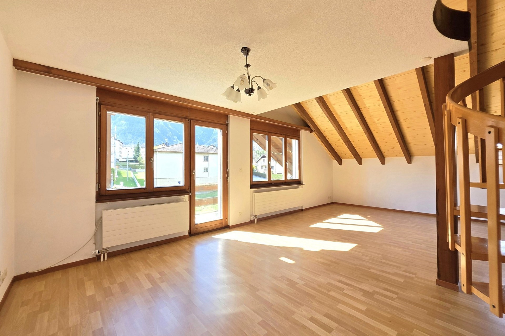 Heller Dachgeschossraum mit Holzdecke und Blick ins Freie