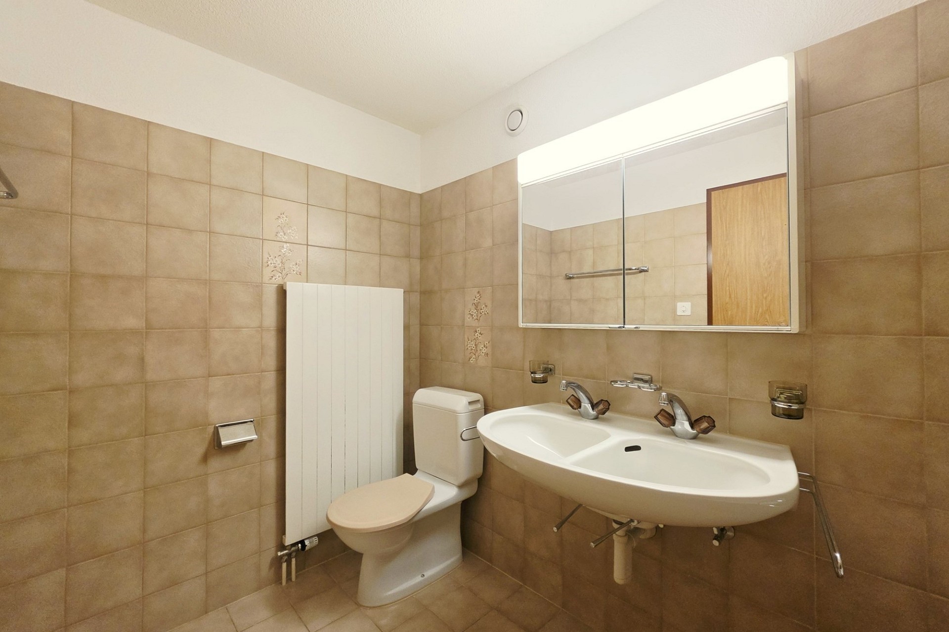 Kleines Badezimmer mit WC und Doppelwaschtisch