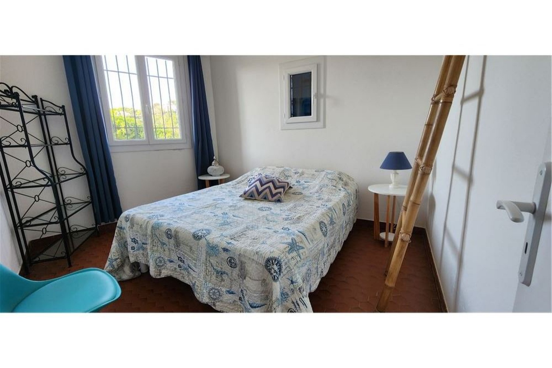 Helles Schlafzimmer mit Doppelbett und Leiter