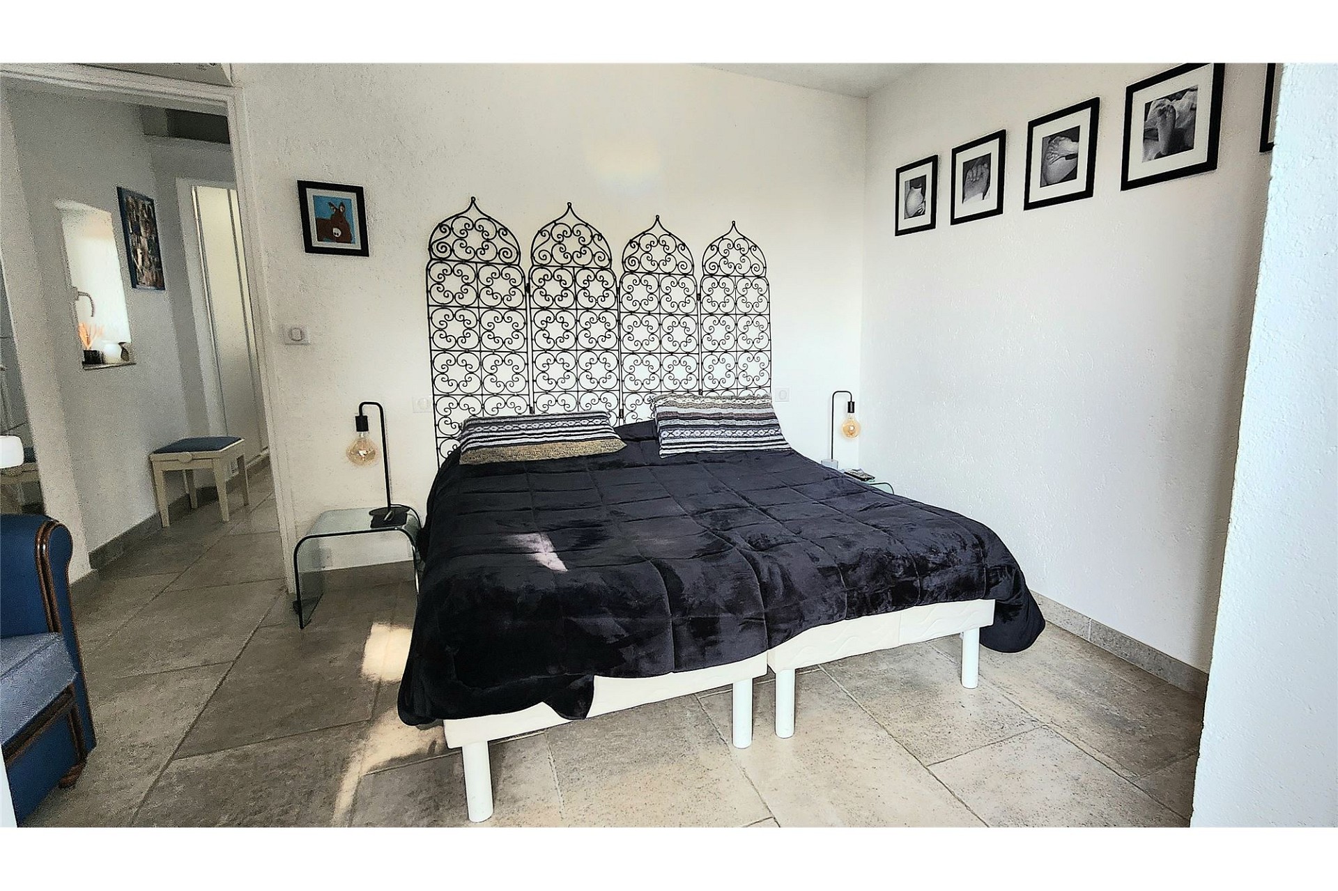 Schlafzimmer mit dunklem Bett und dekorativer Wandgestaltung