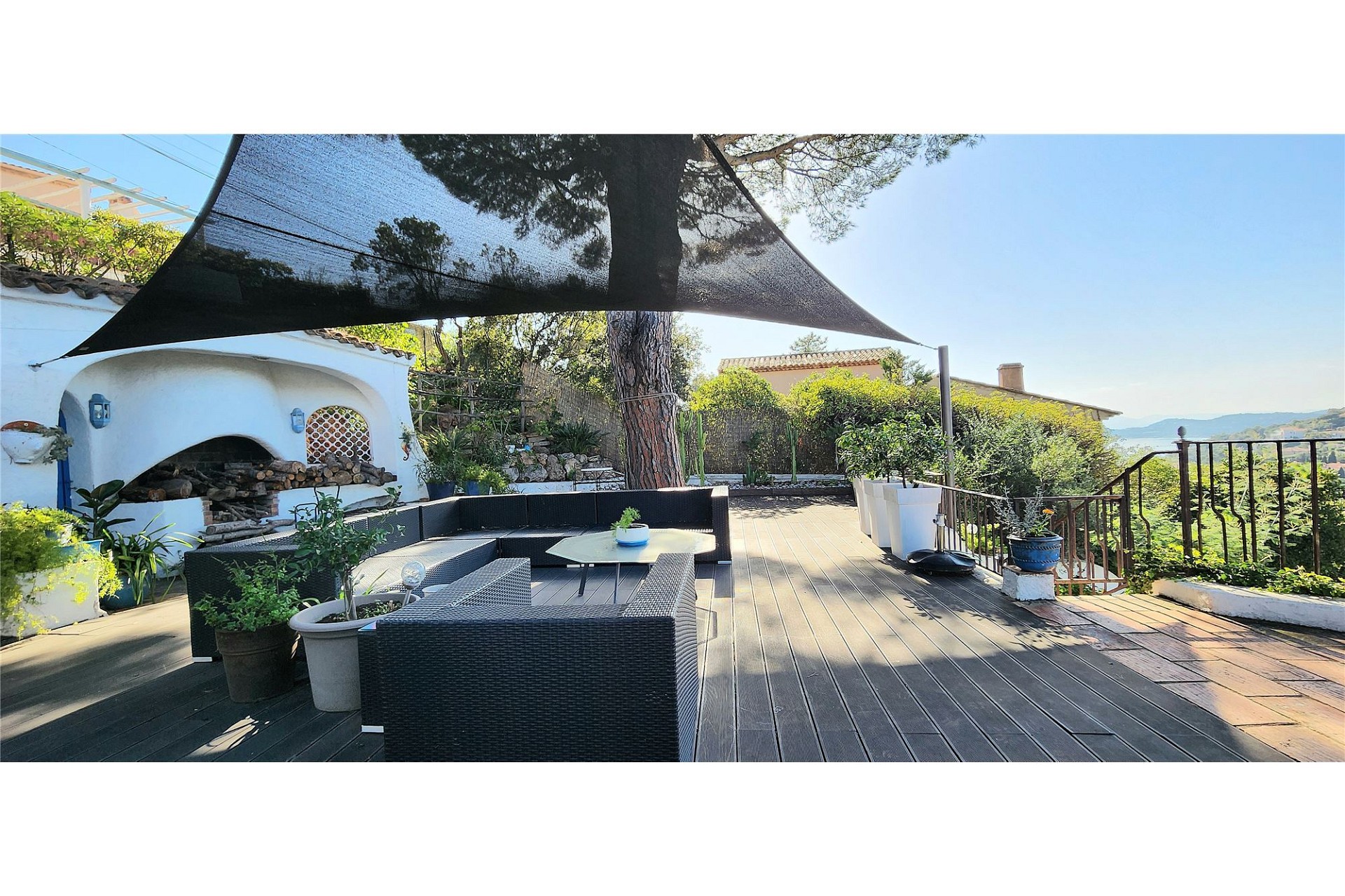 Sonnige Terrasse mit Lounge-Bereich und Außenkamin