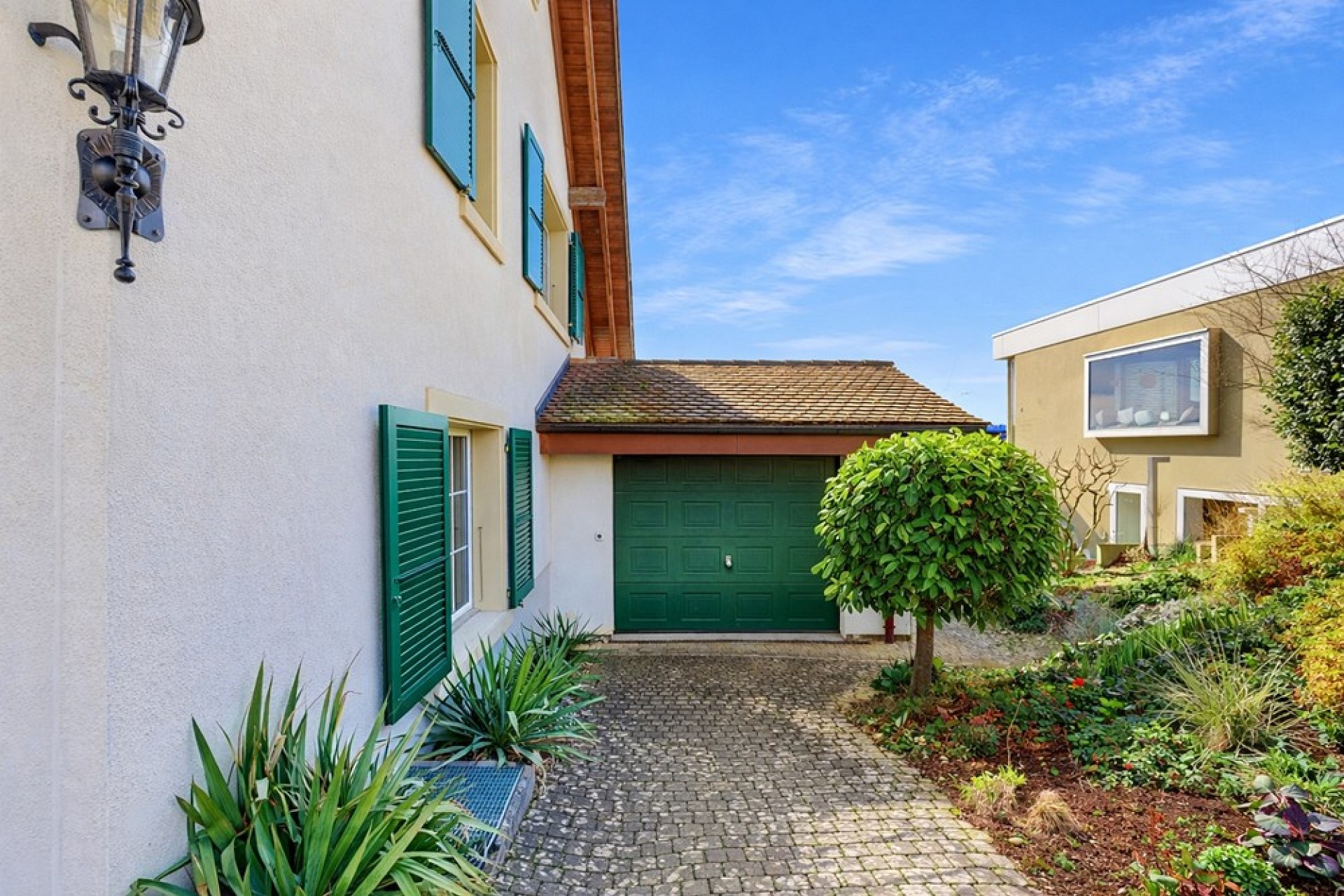 Außenansicht eines Wohnhauses mit Garage und Gartenhof