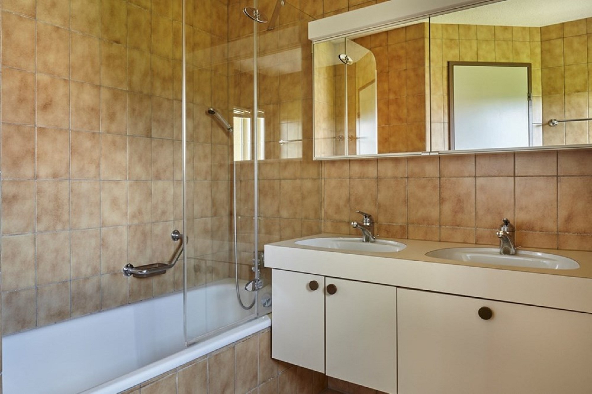 Badezimmer mit Badewanne und Doppelwaschtisch