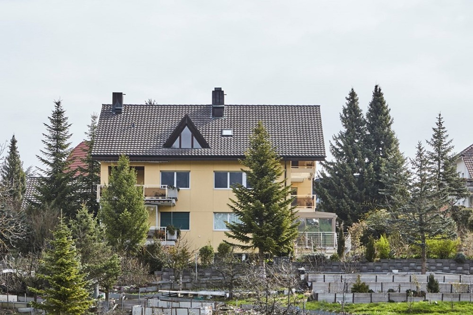 Mehrfamilienhaus mit Walmdach in grüner Umgebung