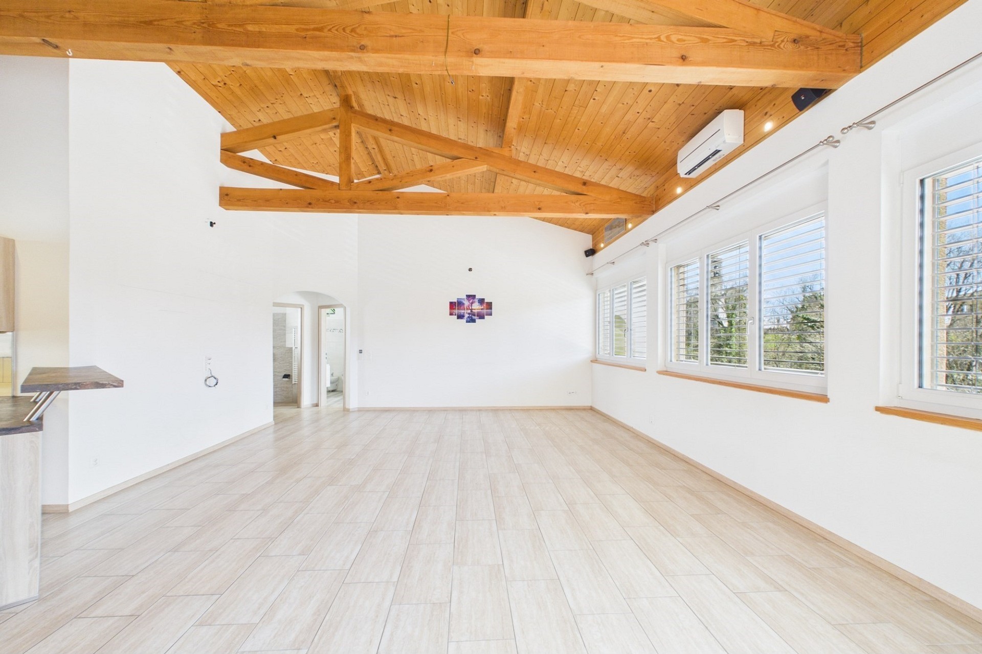 Heller, leerer Wohnraum mit Holzbalkendecke