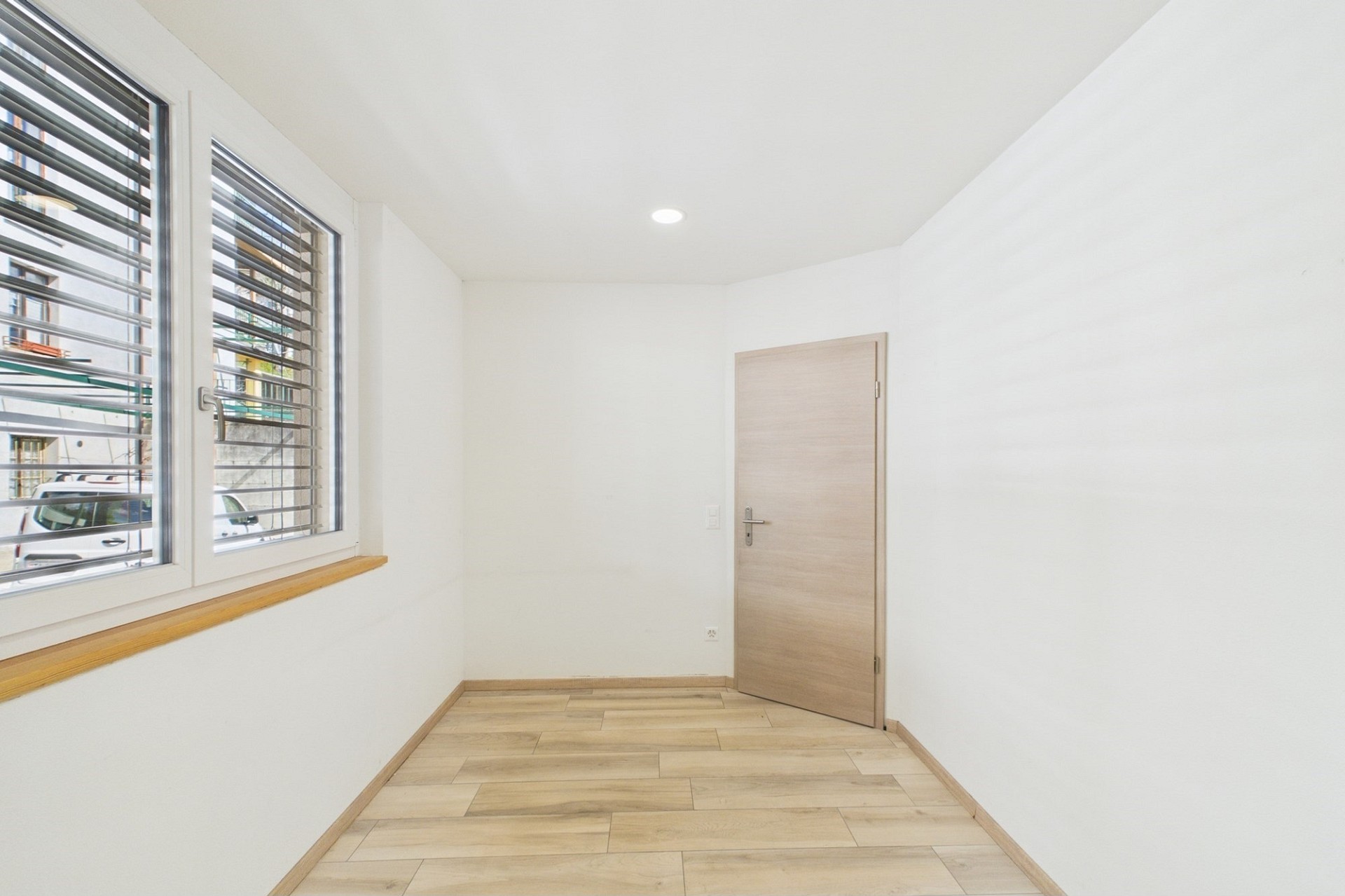 Heller leerer Raum mit Fenster und Holztür