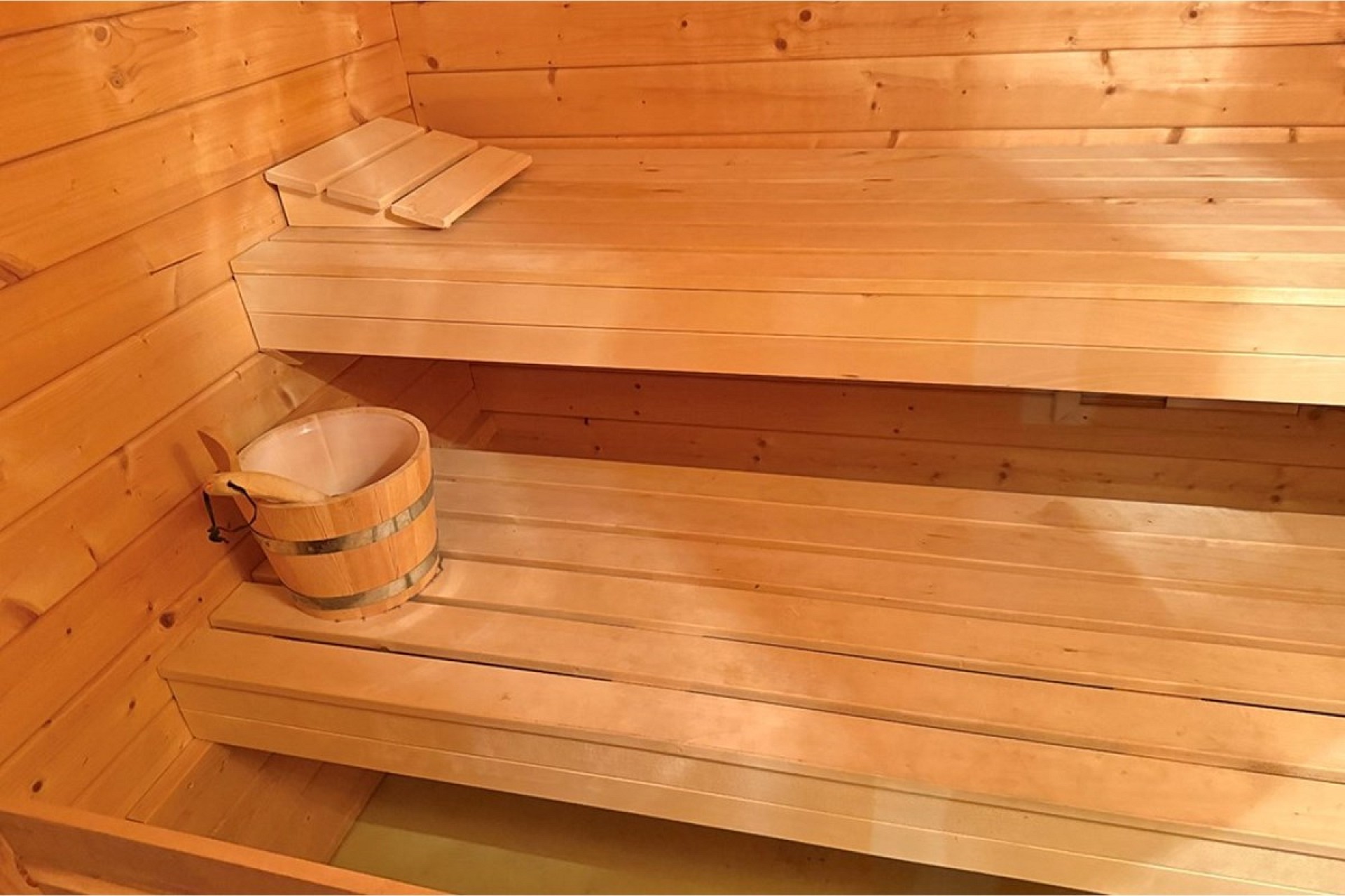 Holzsauna mit Bänken und Kübel
