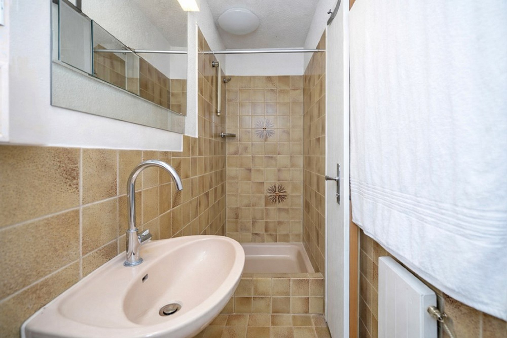 Schmales Badezimmer mit Dusche und Waschtisch